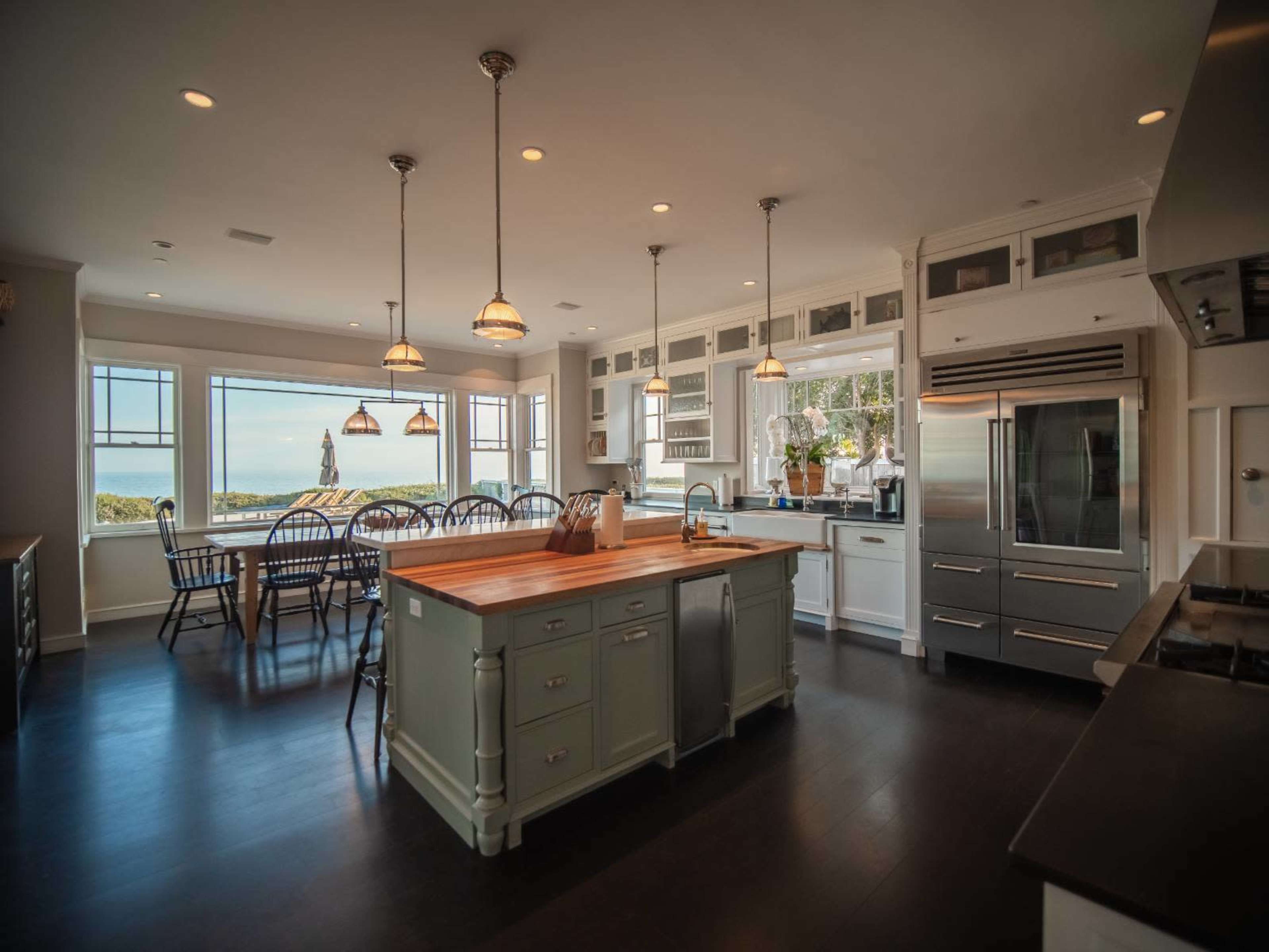 A spacious kitchen with a central island, modern appliances, and a dining area that overlooks a scenic view.