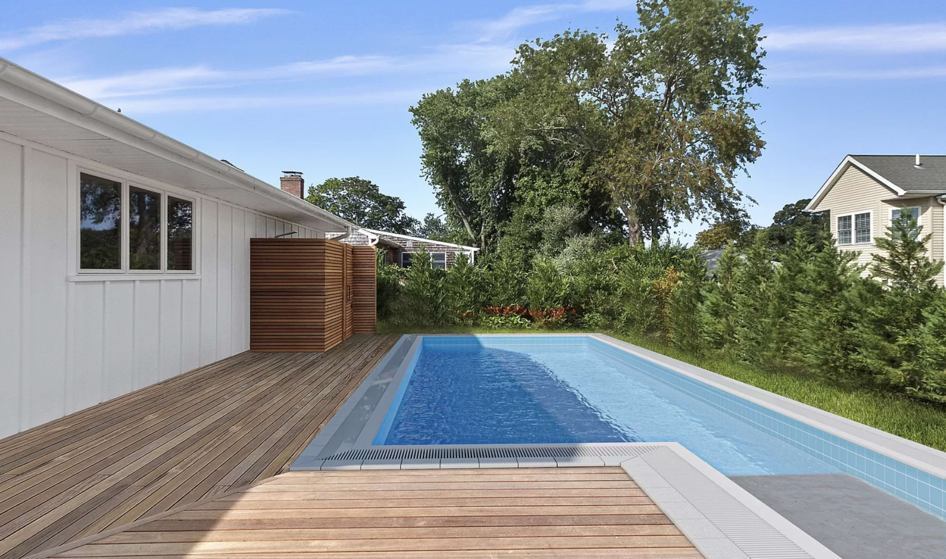 A modern backyard with a rectangular swimming pool adjacent to a wooden deck and surrounded by greenery.
