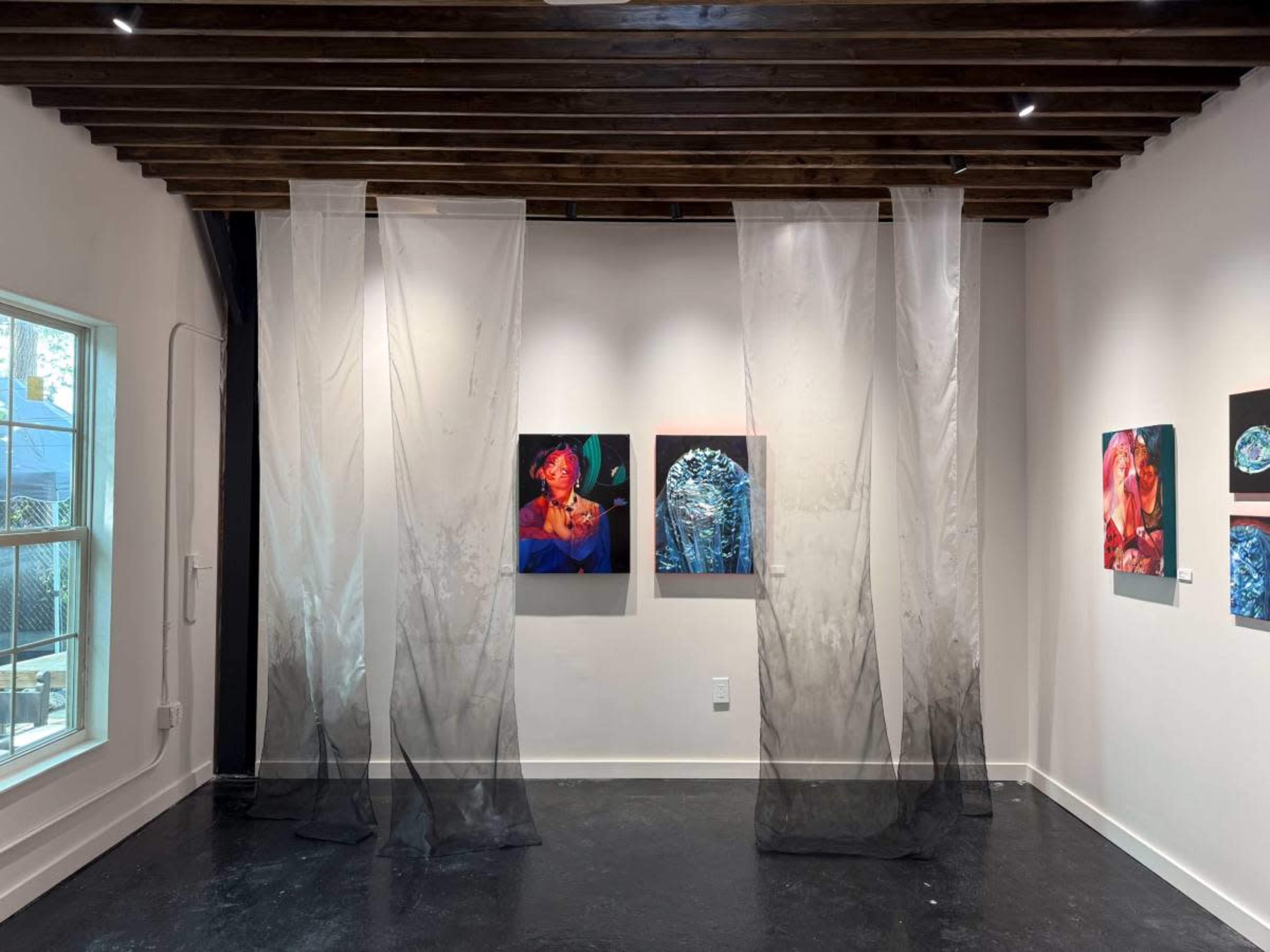 The image shows a contemporary art gallery with sheer curtains dividing the space, featuring vibrant artwork displayed on the white walls.