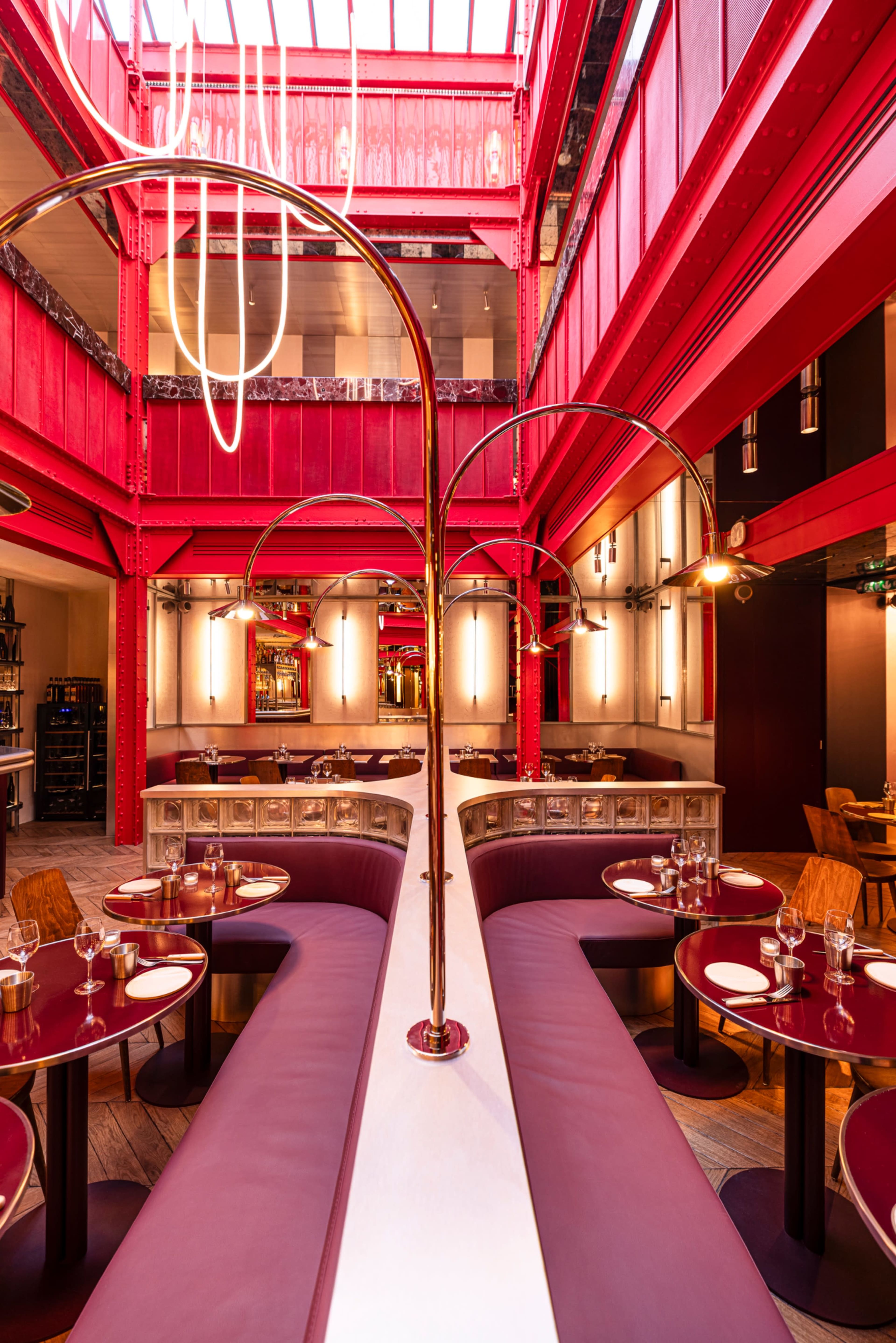 The image shows a modern restaurant interior featuring red walls, sleek seating arrangements, and stylish lighting fixtures.