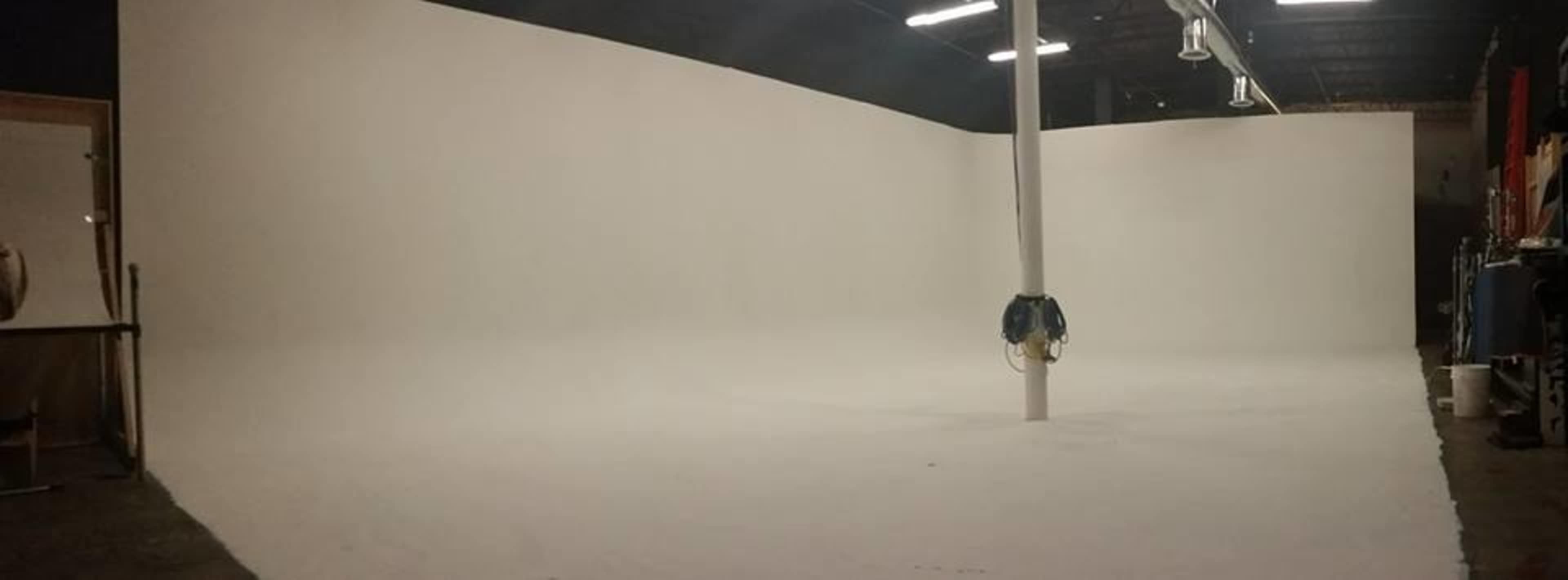 An empty studio space with white walls and a large, flat floor.