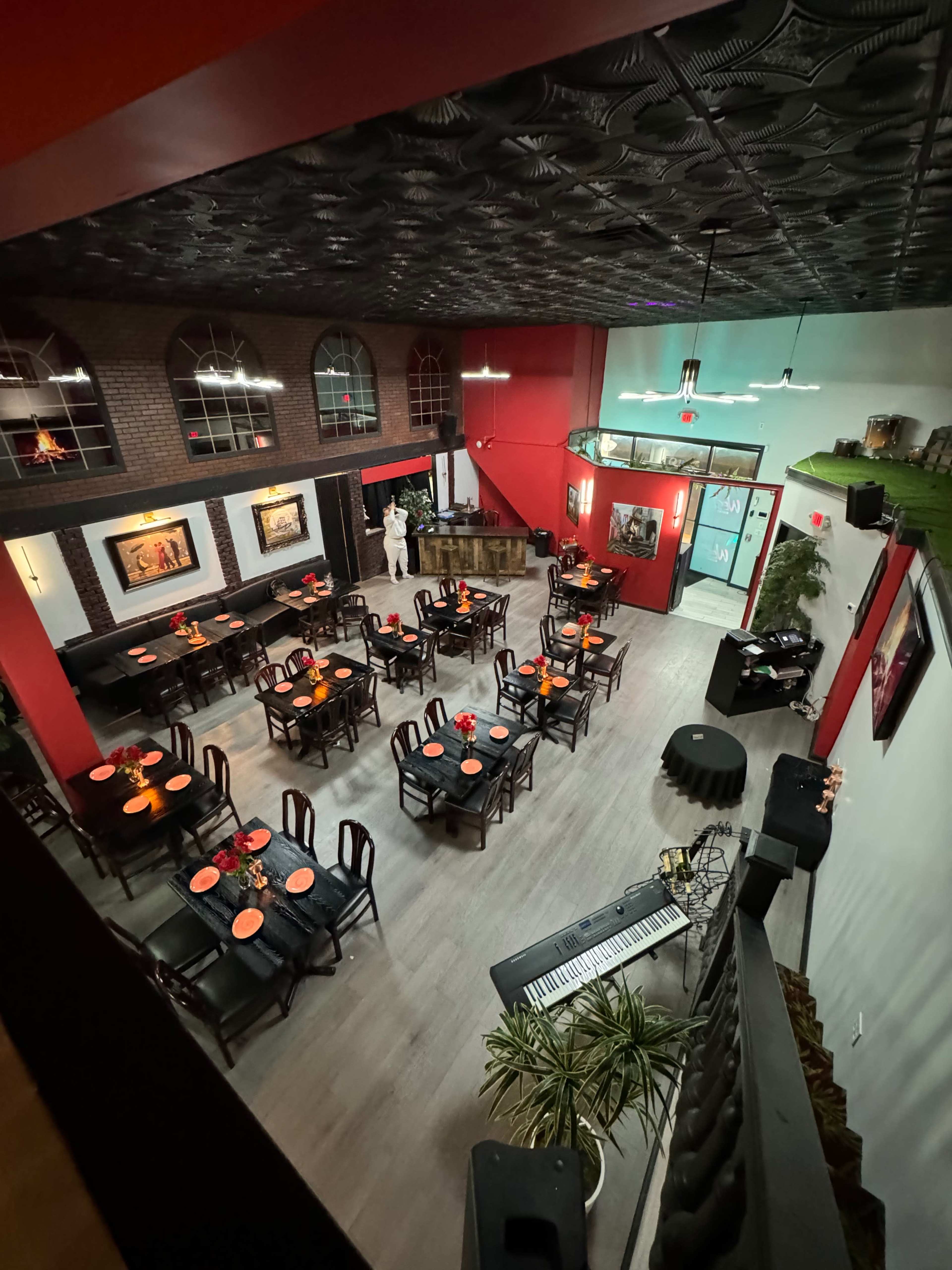 A restaurant interior with tables set for dining, featuring a section for live music and a stage, all within a spacious, well-lit layout.