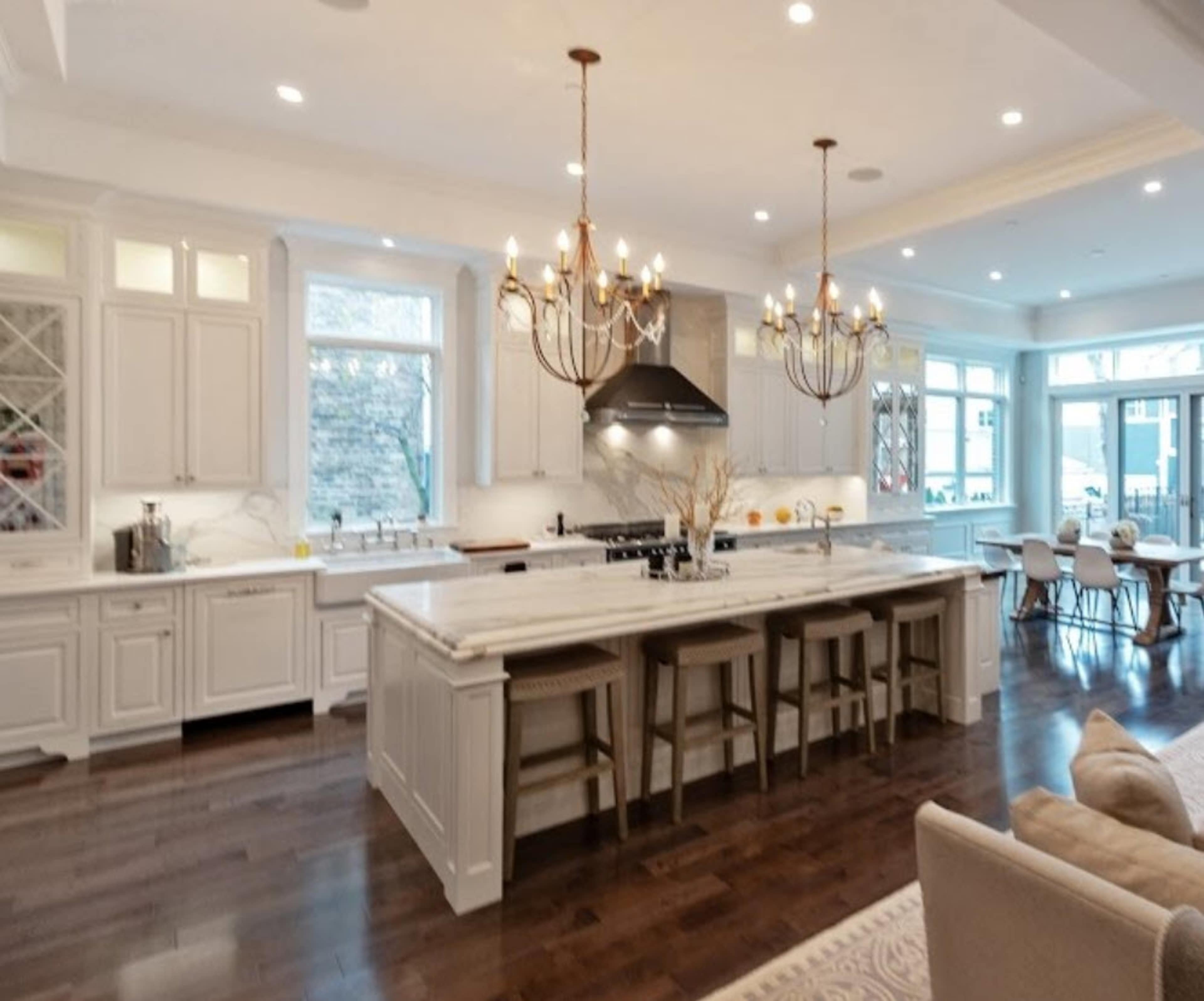 A spacious kitchen features a large island with seating, modern appliances, and a dining area bathed in natural light.