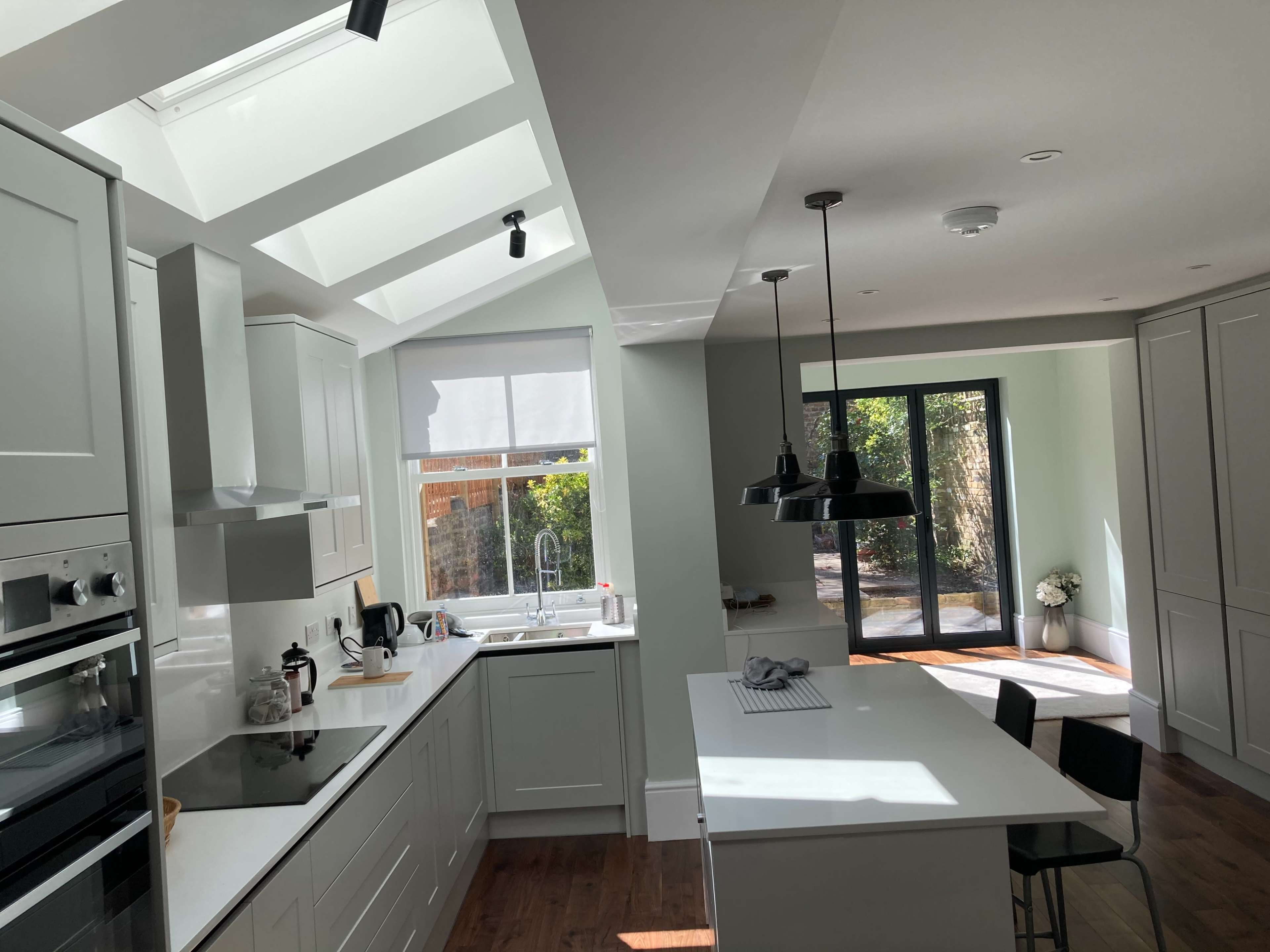 The kitchen features modern cabinetry, an island with seating, and large windows that allow natural light to fill the space.