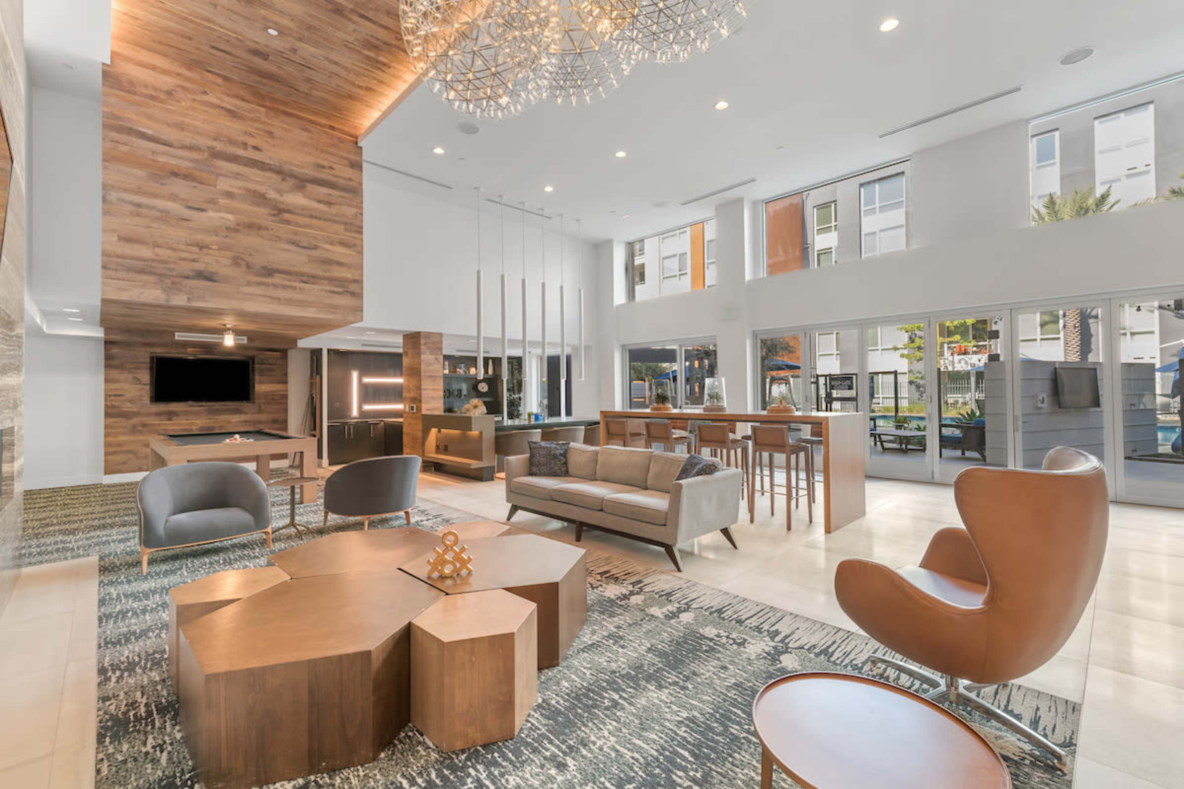 A modern lobby with wood accents, contemporary furniture, and large windows allowing natural light to fill the space.