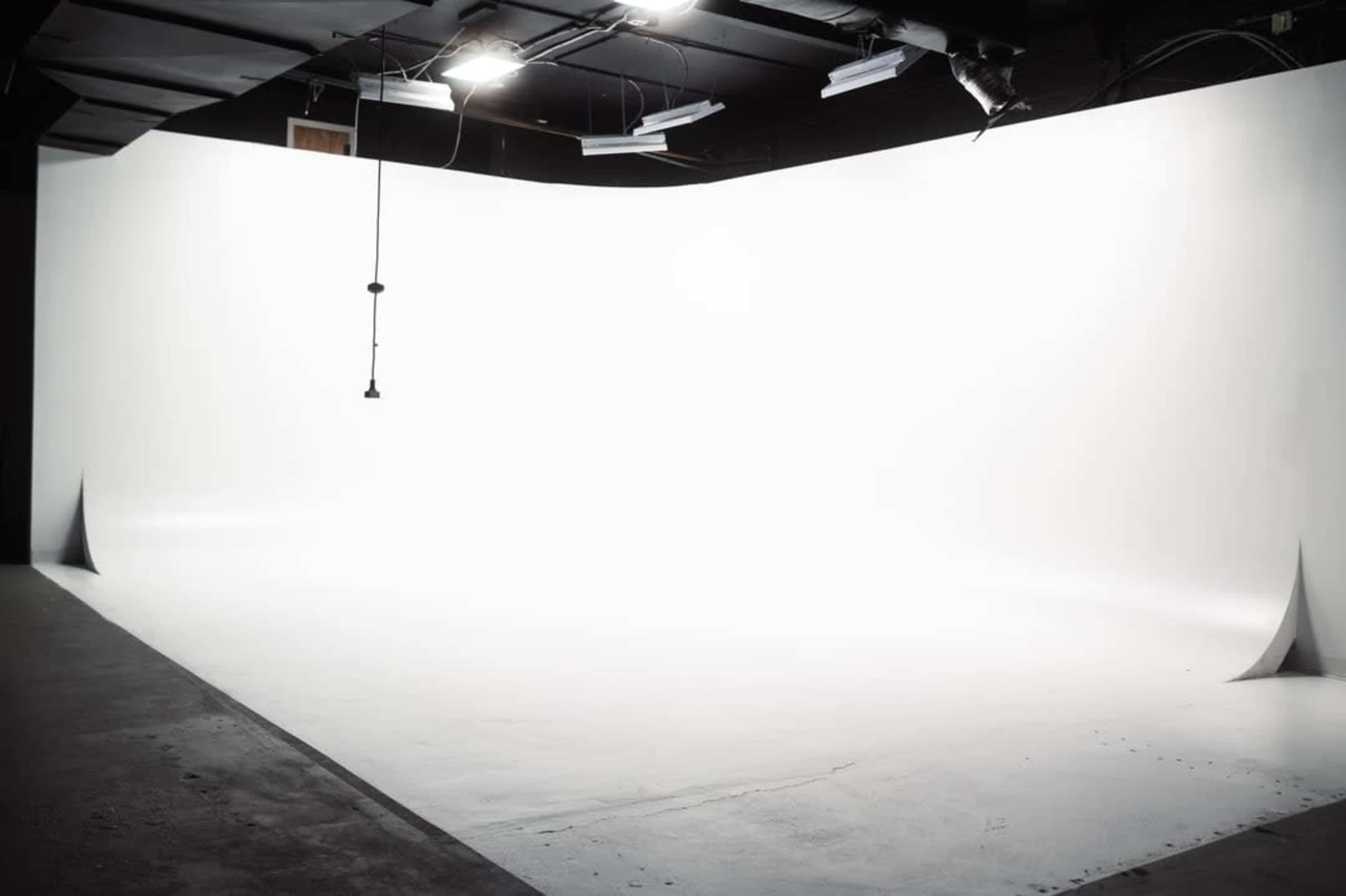 A spacious photography studio with a large, curved white backdrop.
