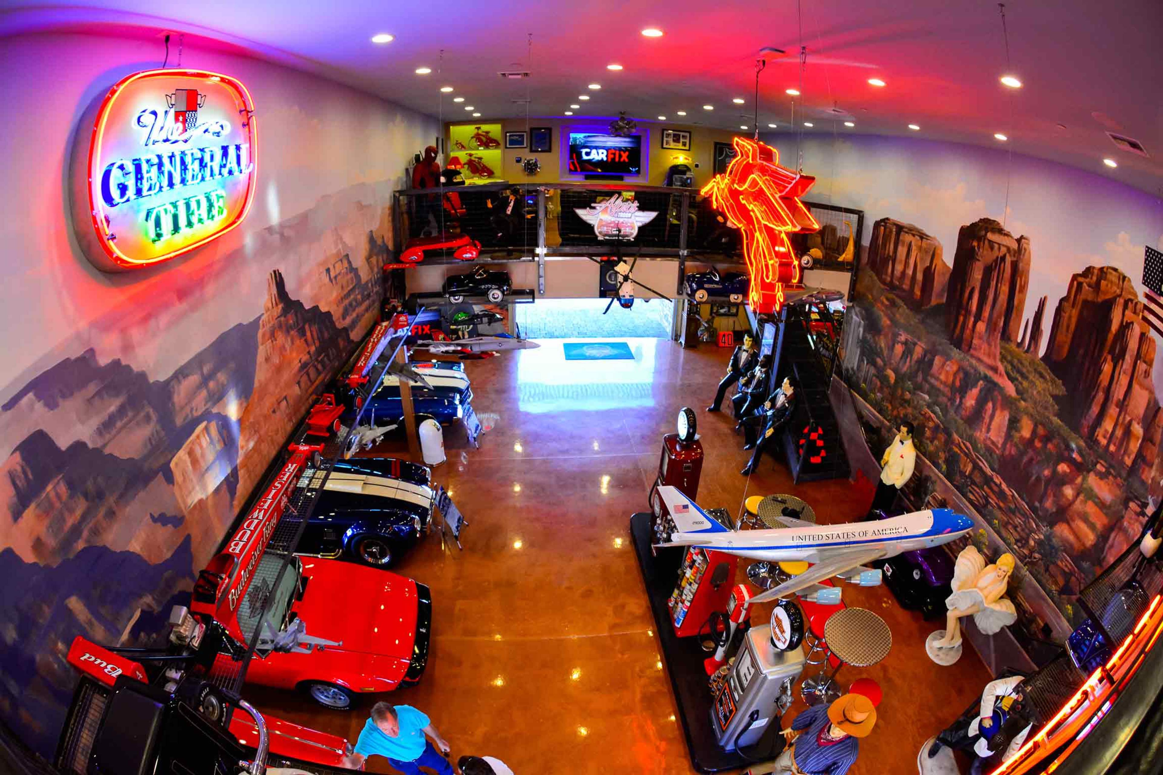 A vibrant car-themed museum filled with classic cars, neon signs, and various automotive memorabilia displayed in a spacious room.
