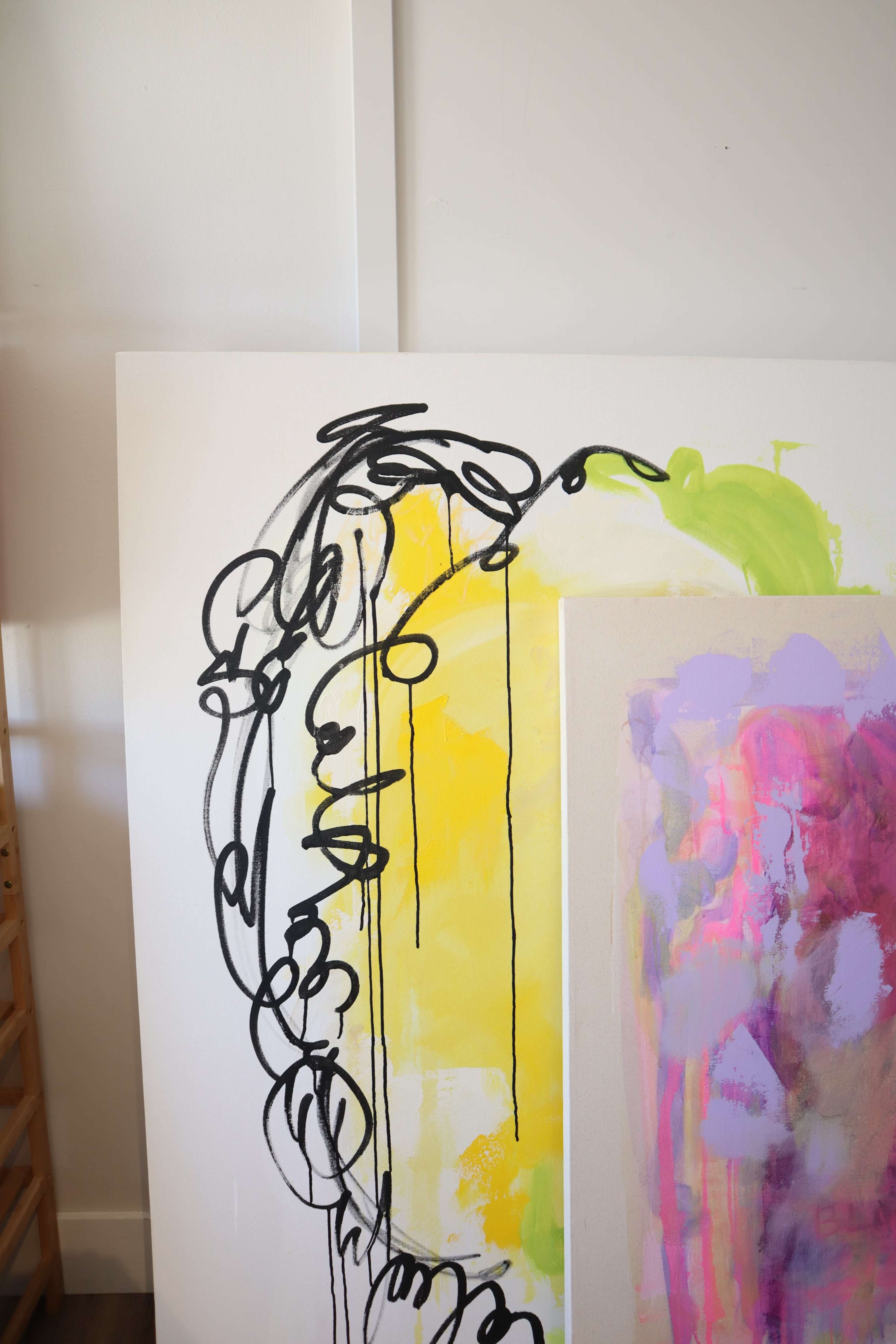 The image features a close-up of an abstract painting with bold black lines and vibrant yellow, pink, and green colors on a white background.