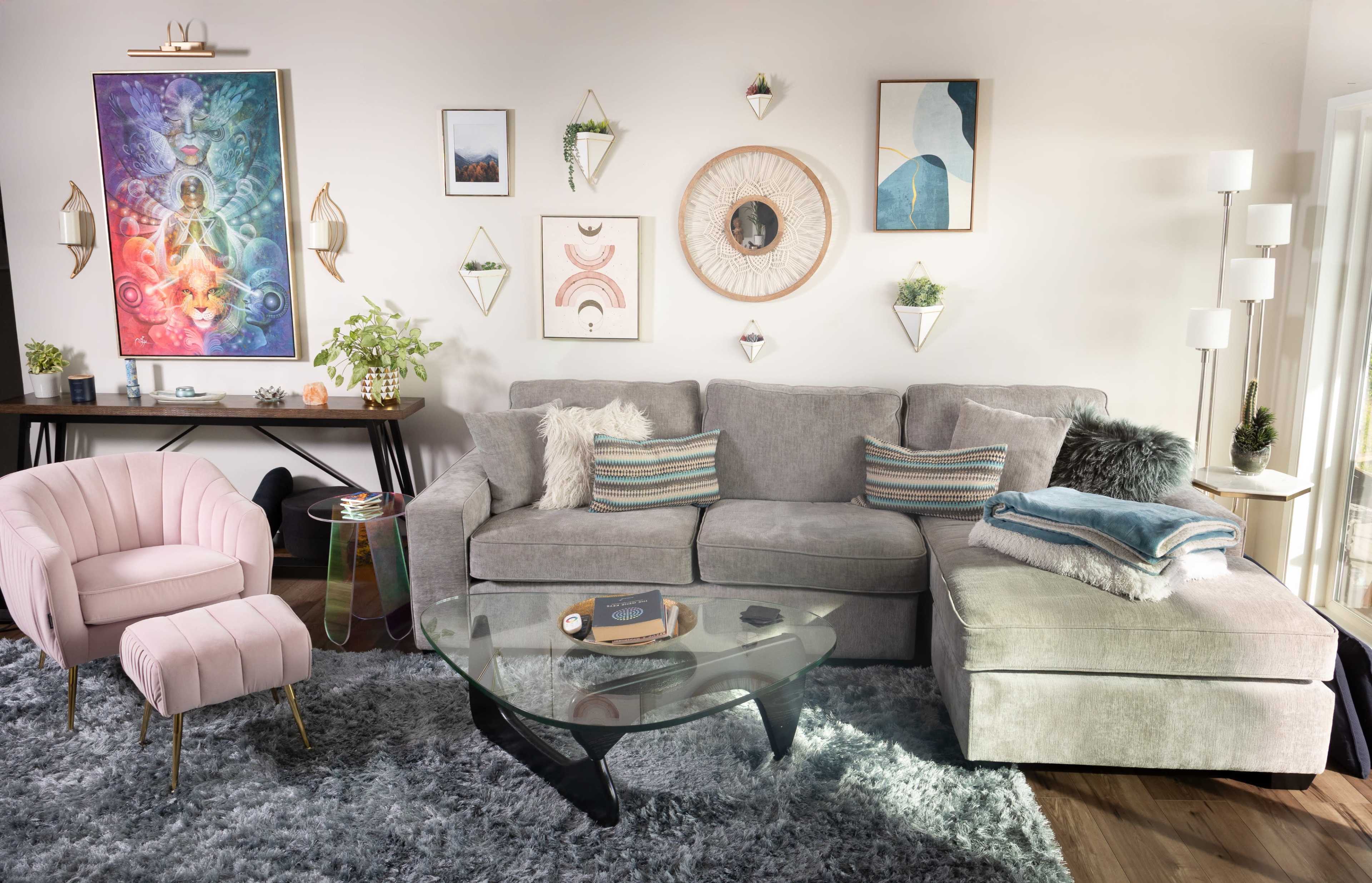 The scene depicts a cozy living room with a light gray sectional sofa, a glass coffee table, and various decorative items including wall art and plants.