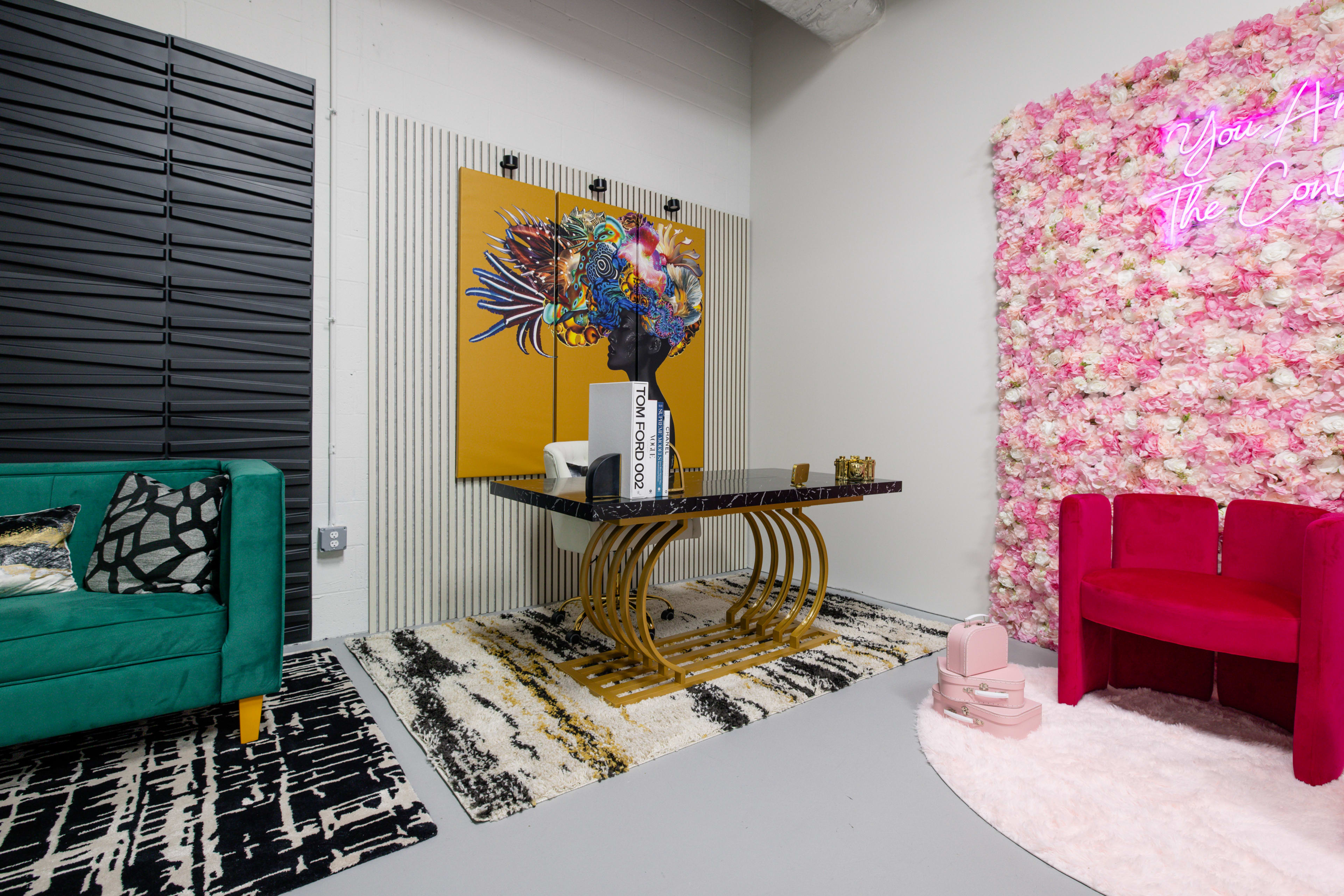 A stylish room with a floral accent wall, a modern dining table, a plush carpet, and colorful seating arrangements.