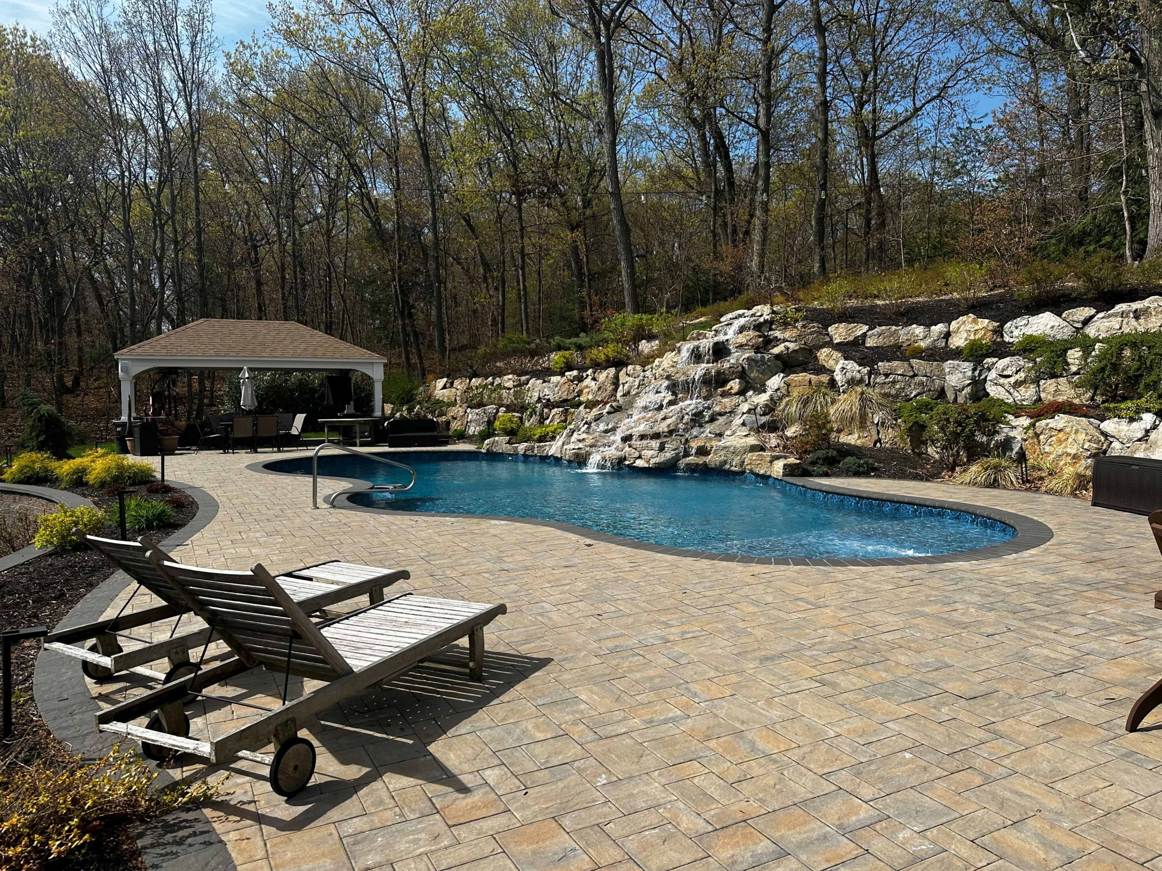 Resort style backyard with pool, pavilion, surround sound speakers and grills Image in Huntington, Melville, NY