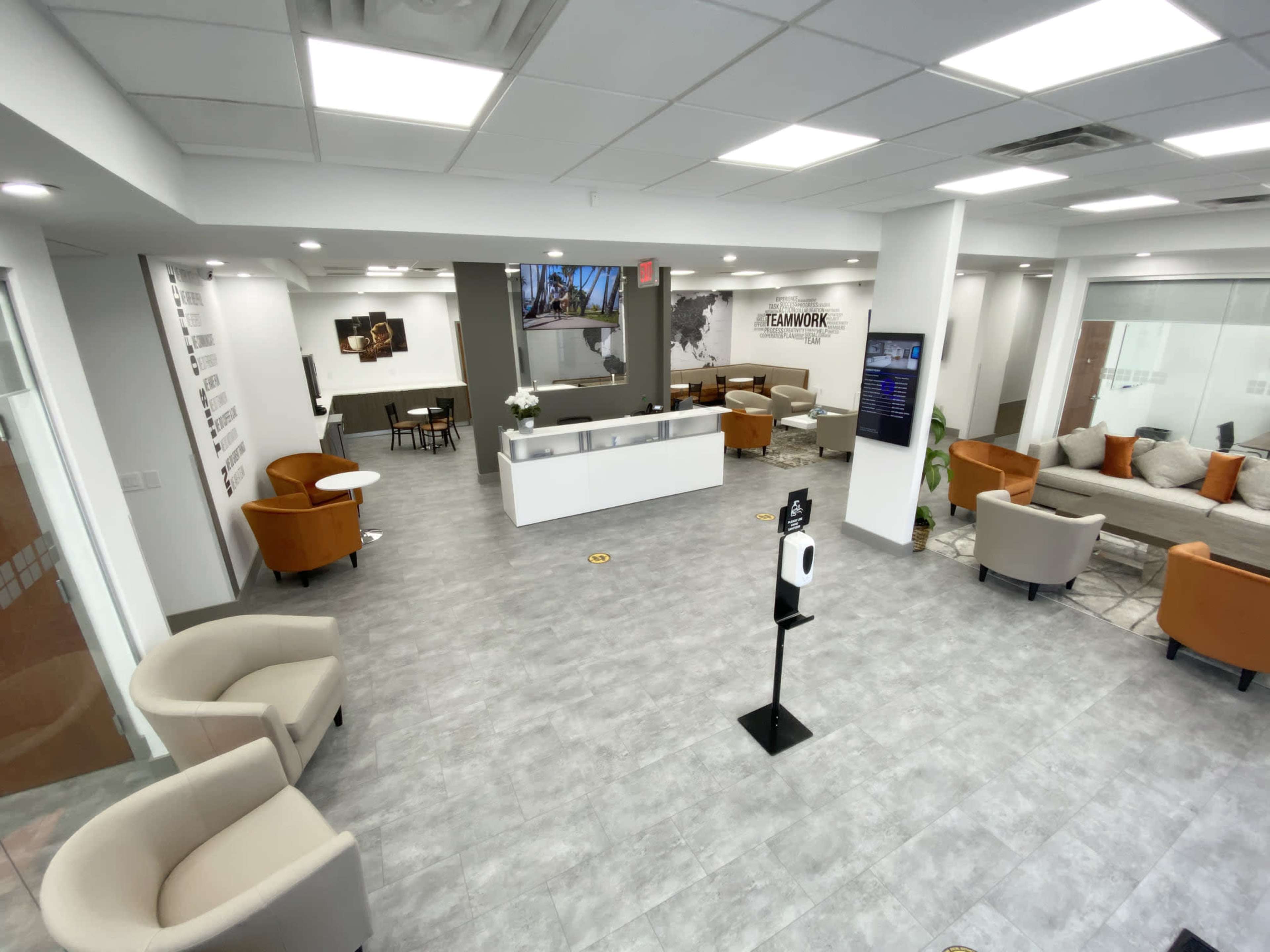 A modern office reception area with seating, collaborative spaces, and a front desk.