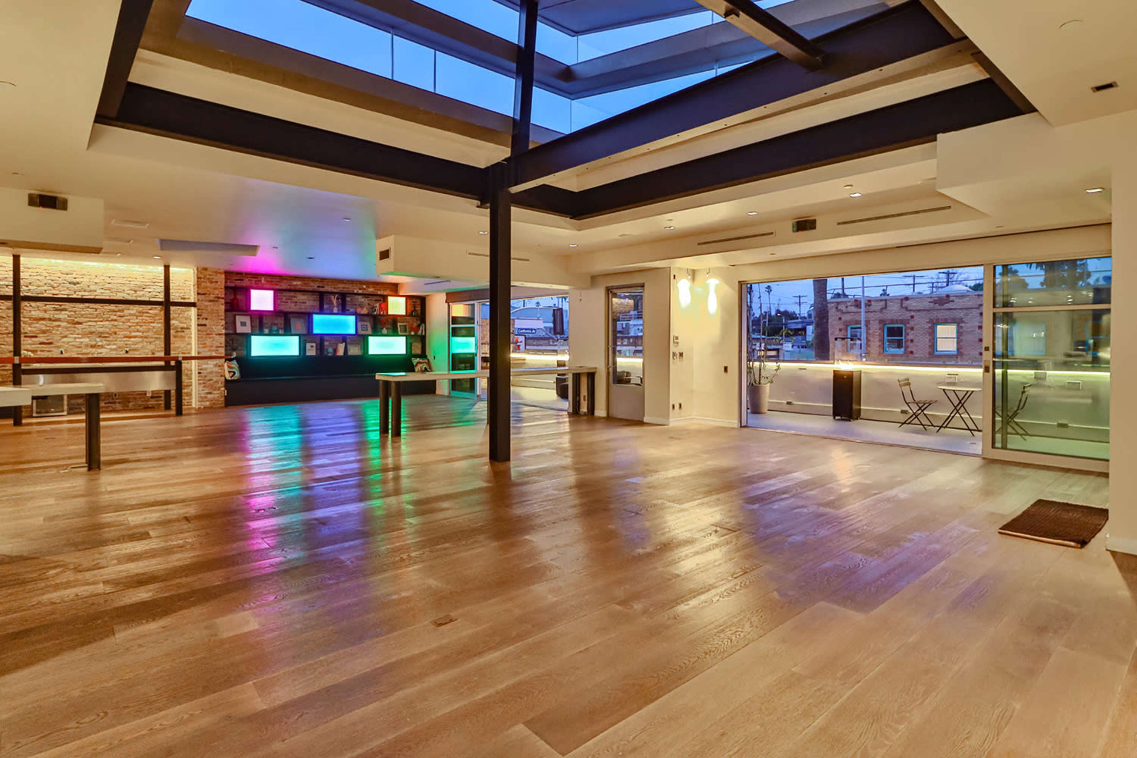 The spacious interior features wooden flooring, large windows, and modern lighting, creating an open and contemporary environment.