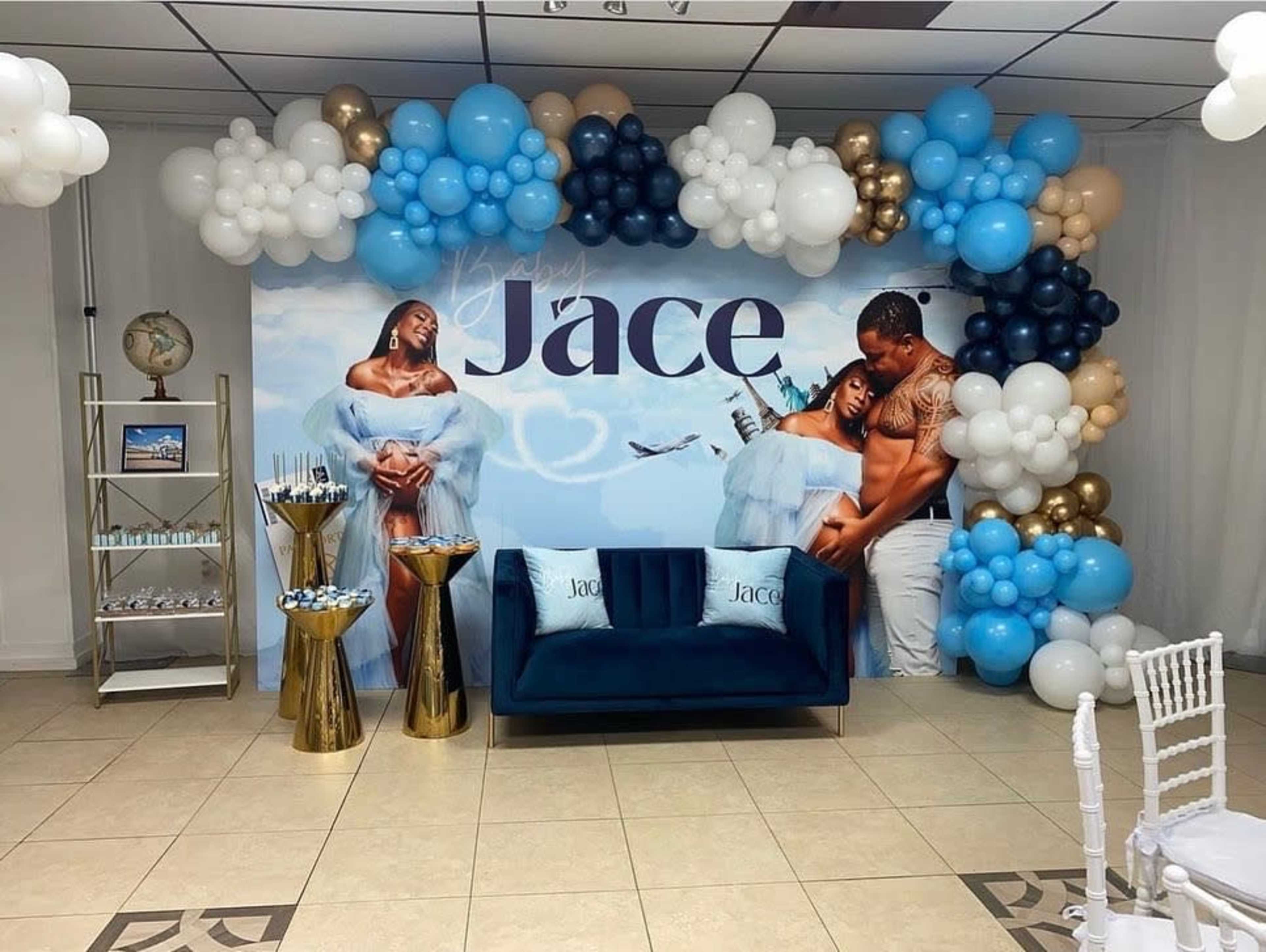 The image features a decorated event space with a backdrop displaying the name "Jace," surrounded by balloons and a couple posing together, along with a blue sofa and refreshments on display.