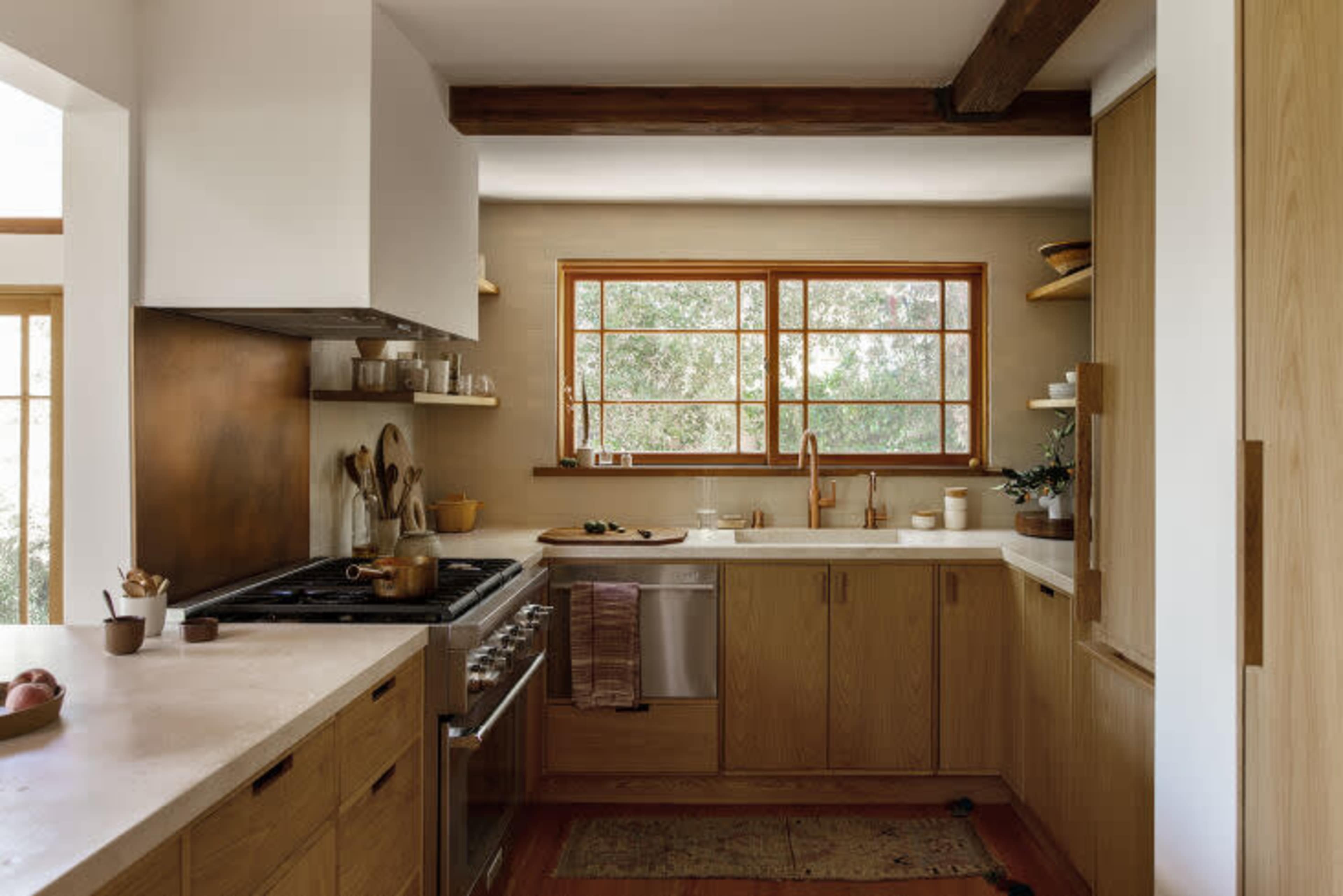 The kitchen features wooden cabinetry, a large sink, and a window that brings in natural light.