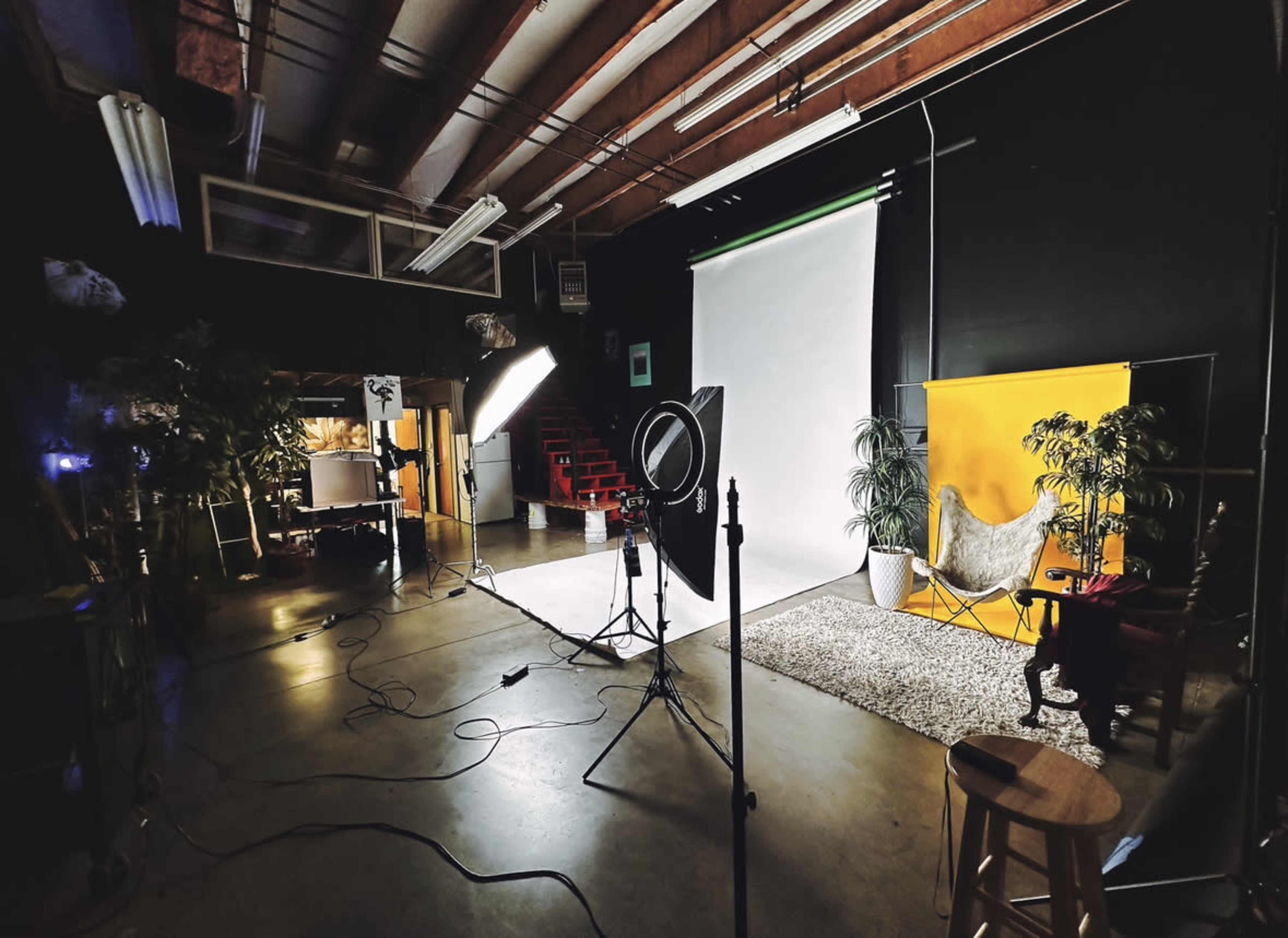 A photography studio setup with a backdrop, lighting equipment, and various props arranged for a photoshoot.