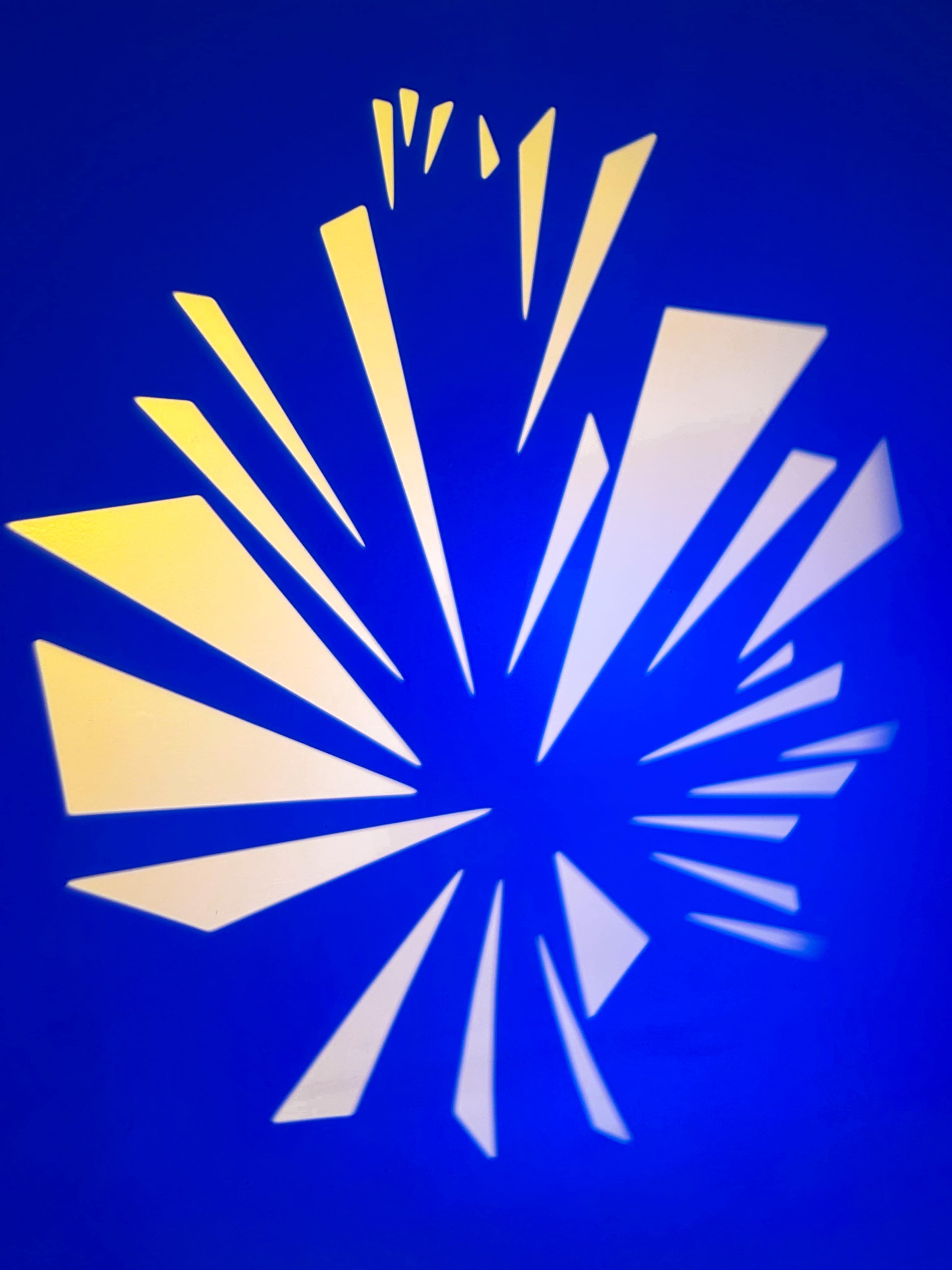 The image features an abstract design of sharp, angular shapes casting a shadow against a blue background.