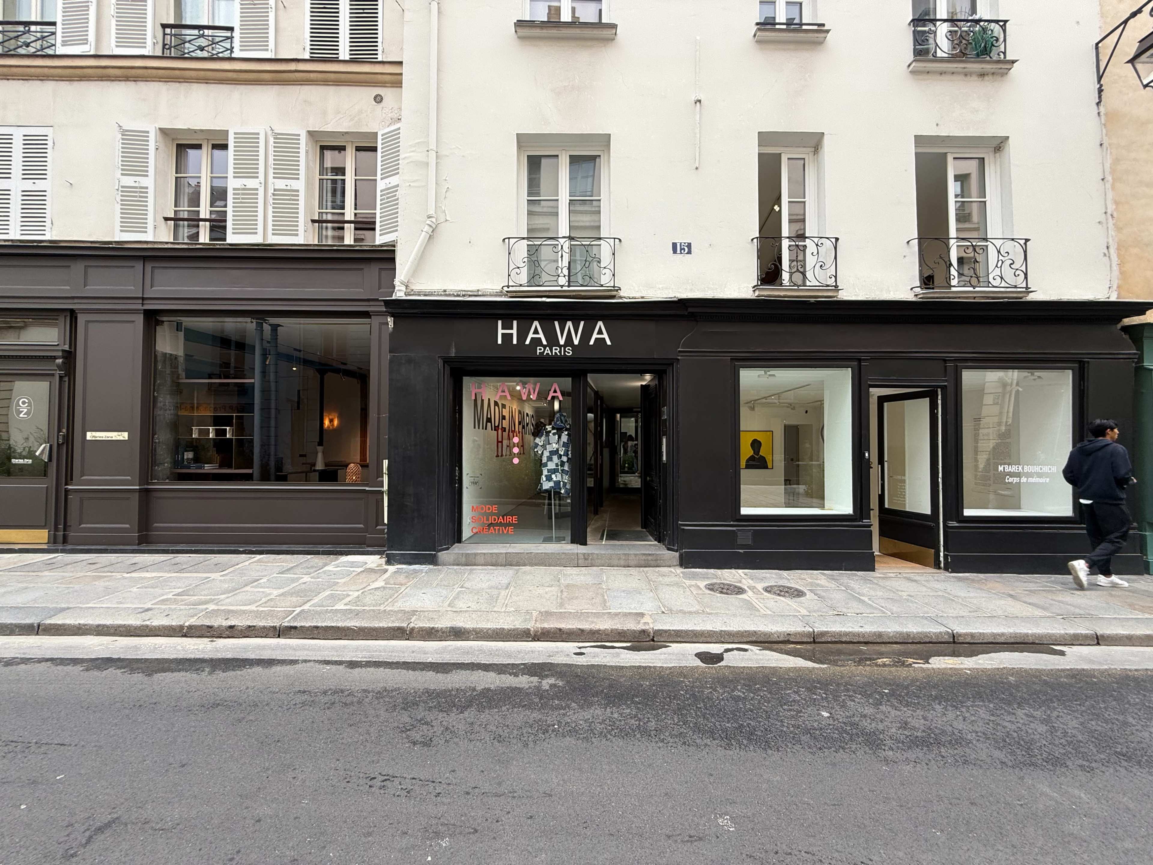 The image shows a storefront labeled "Hawa" in Paris, flanked by buildings with windows and balconies.