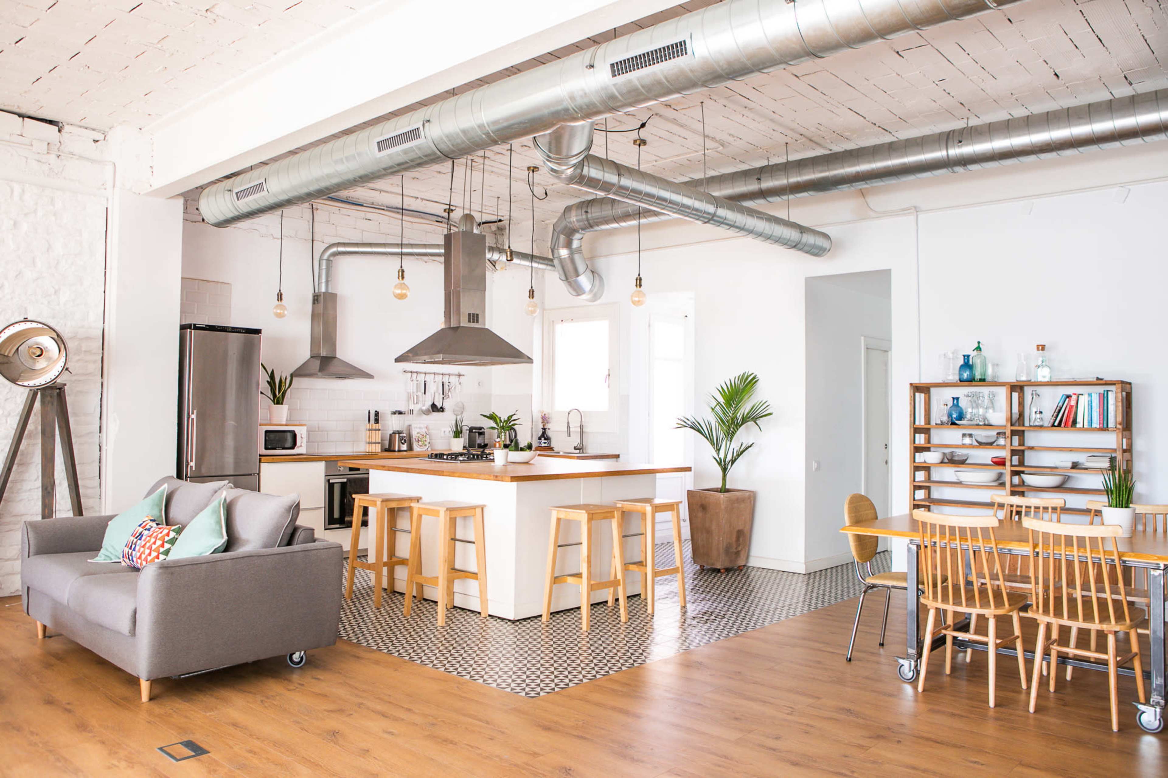 A modern open-concept kitchen and living area featuring a kitchen island, dining table, and stylish furnishings.