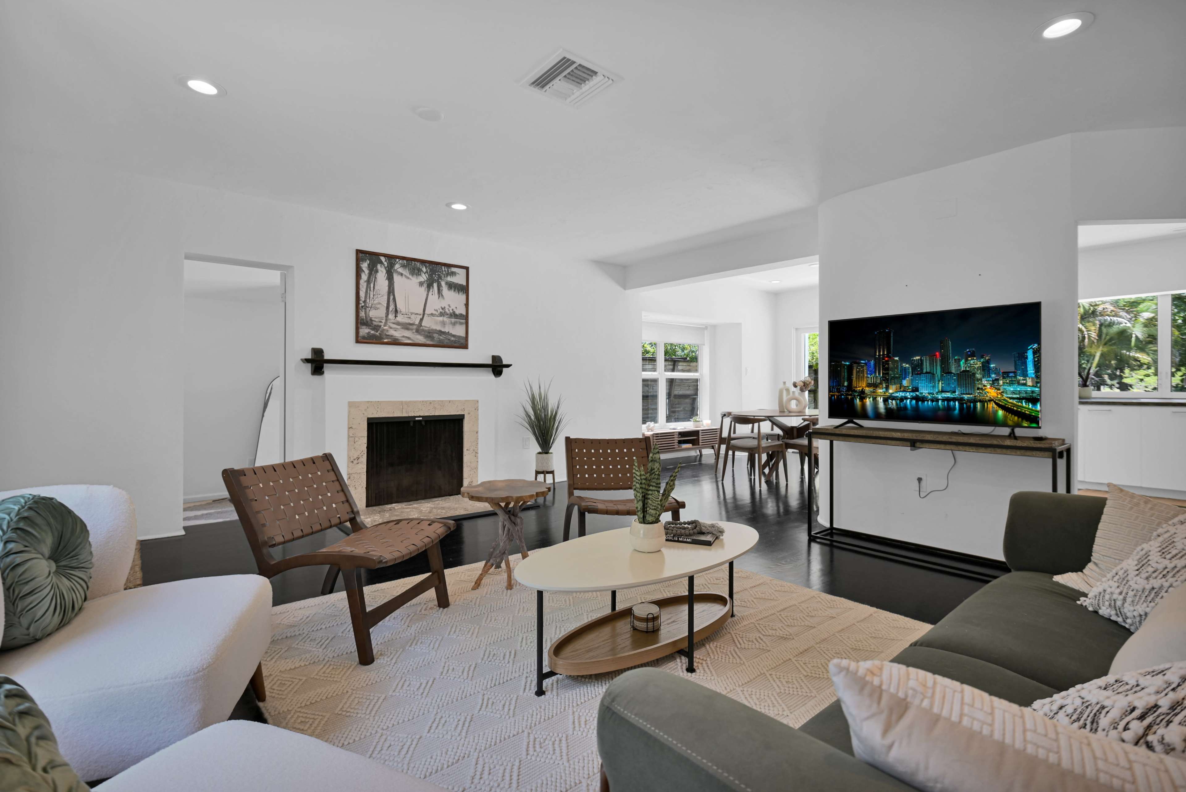 A modern living room features a fireplace, a television on a stand, and a seating area with a coffee table.