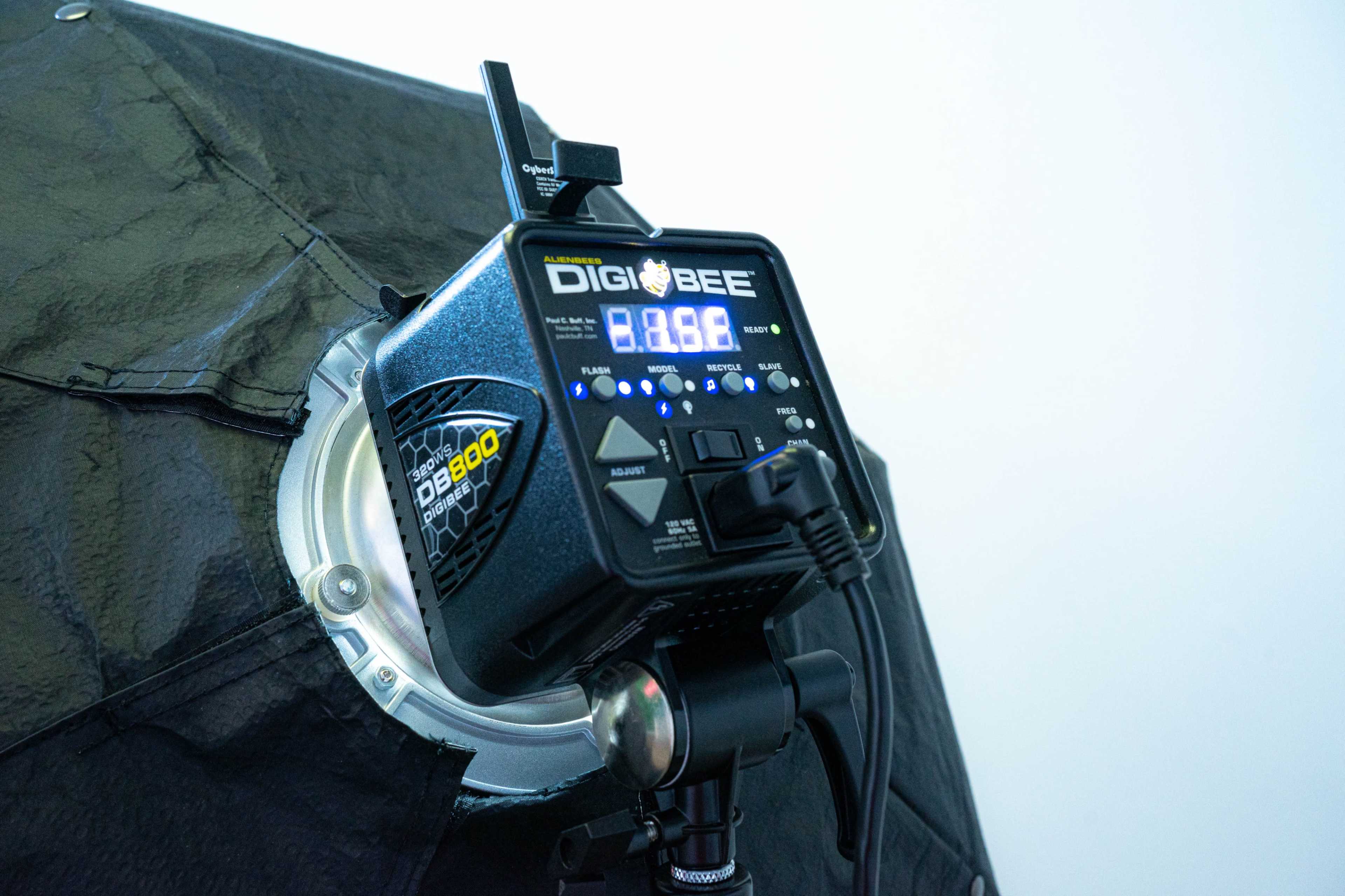 A close-up of a DigiBee lighting controller mounted on a softbox.