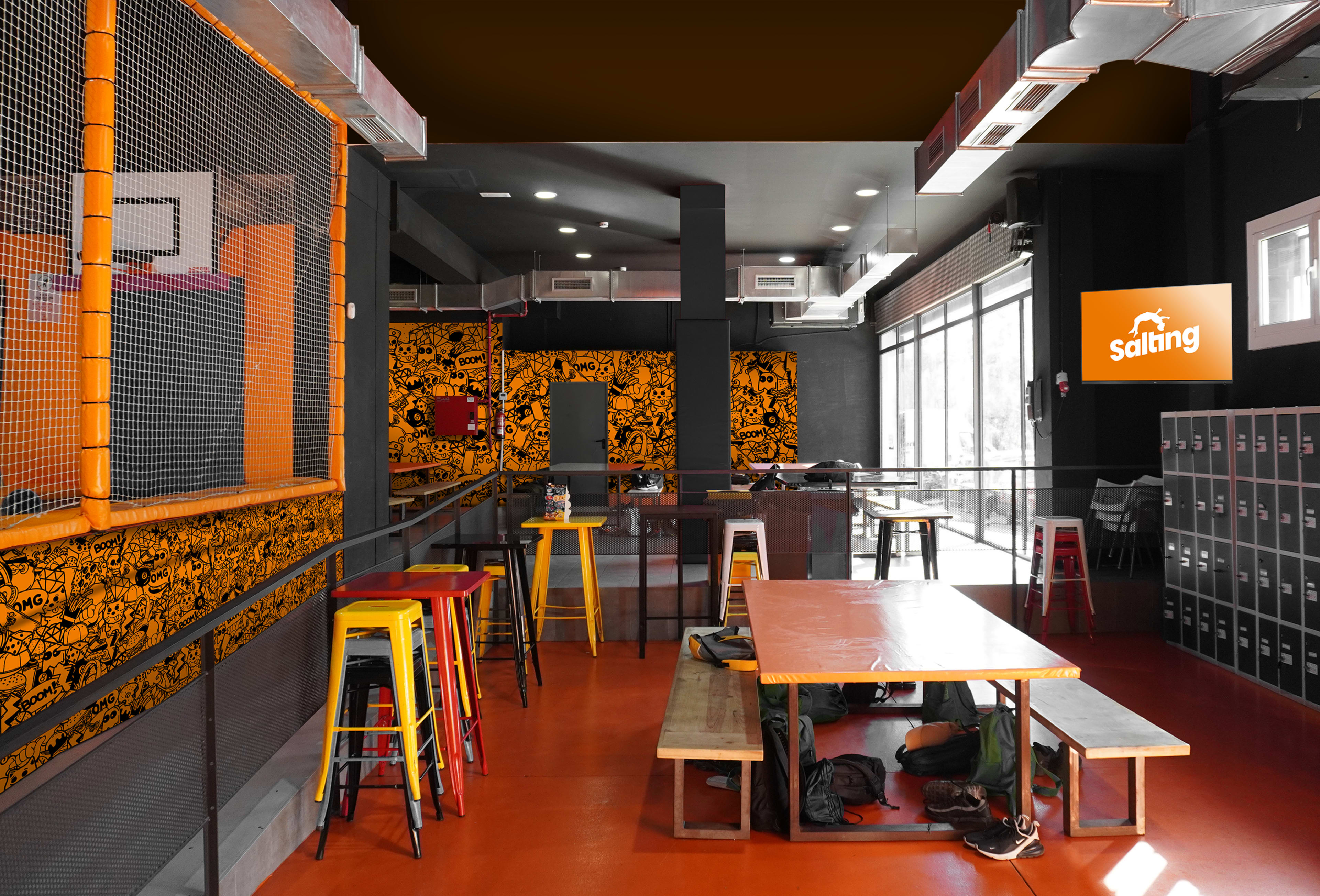 An indoor space of a restaurant or café featuring colorful seating, walls decorated with bold artwork, and metal lockers along one side.