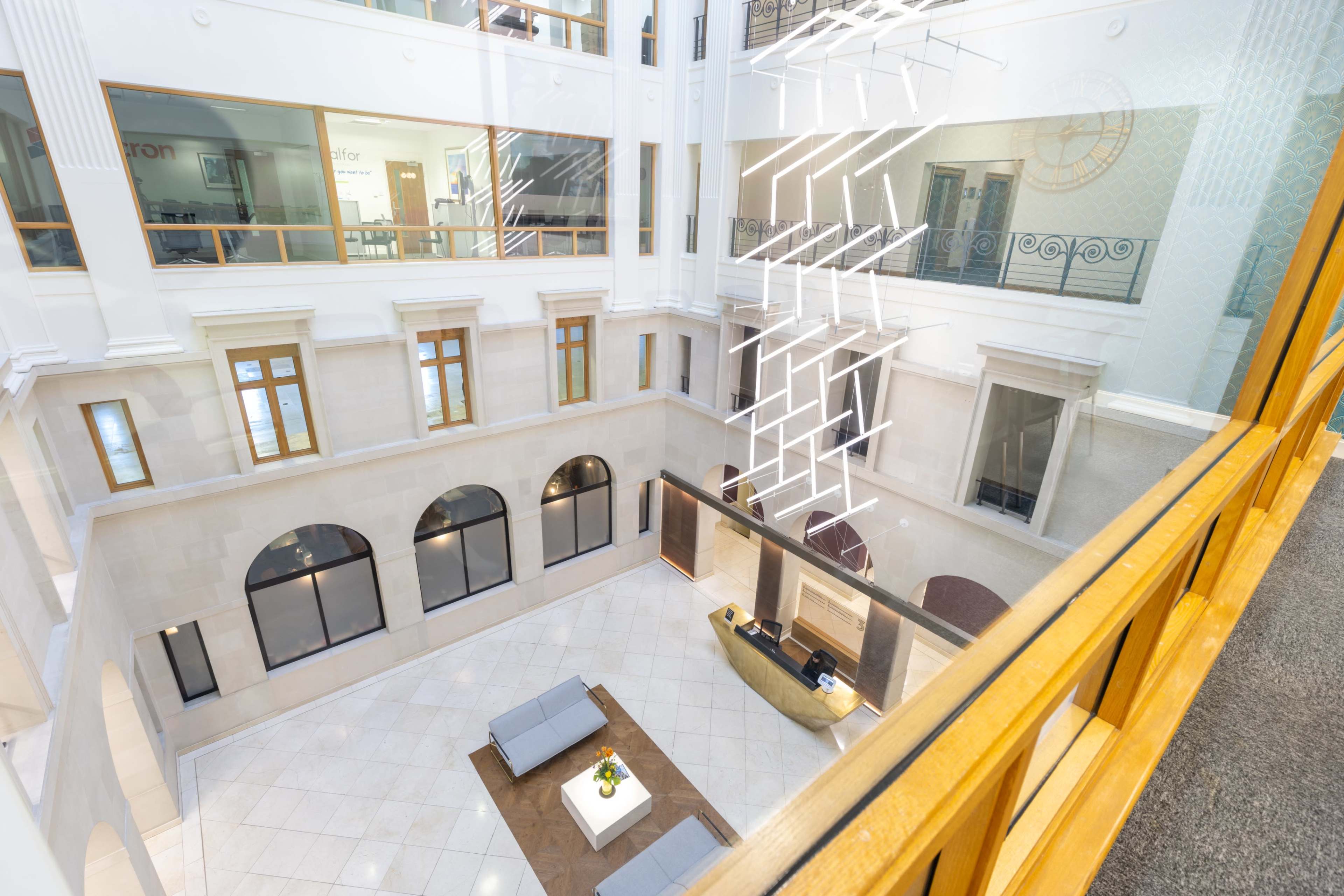 An open atrium with a modern design featuring a seating area and artistic lighting elements.