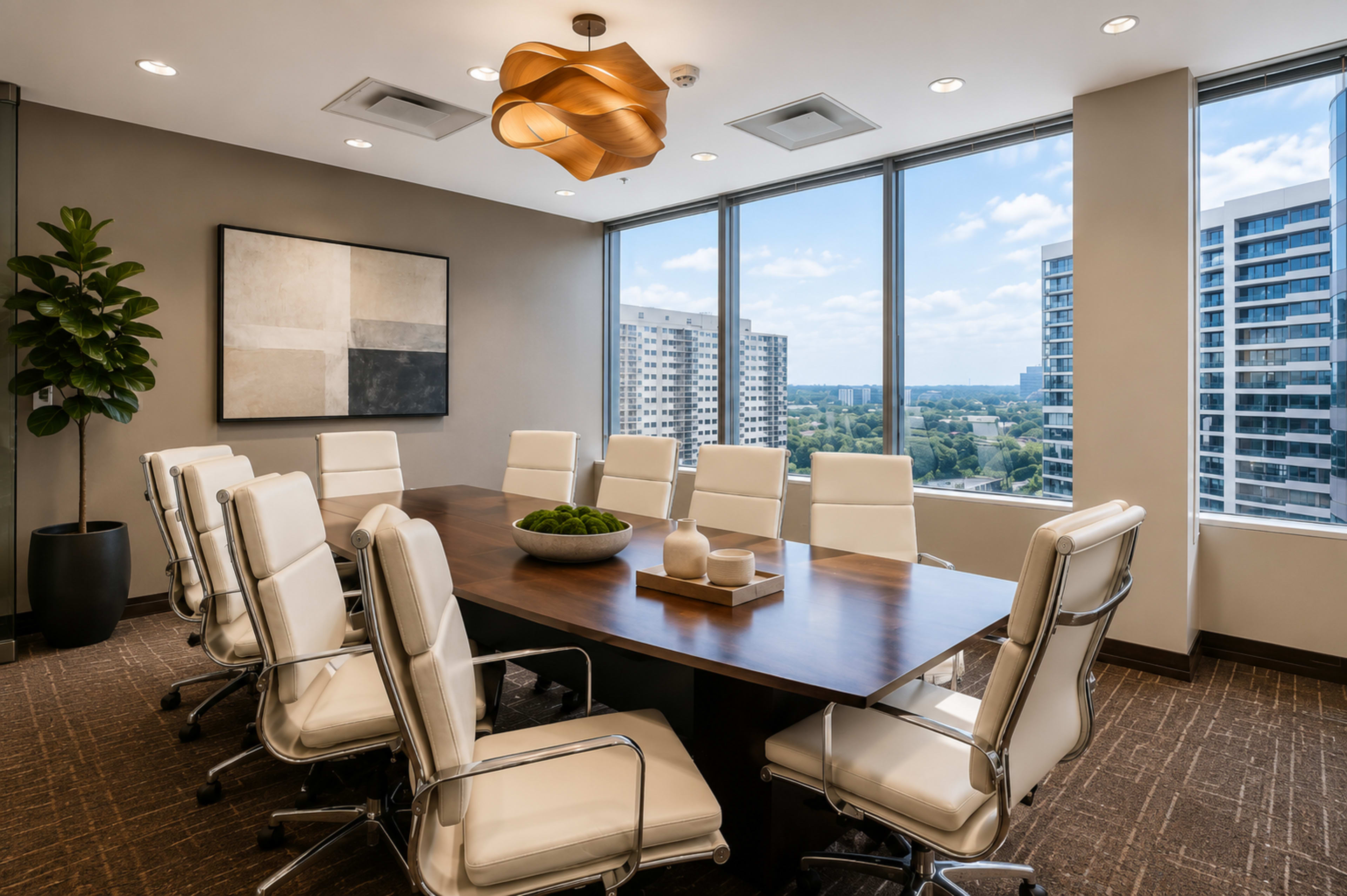 A modern conference room features a long wooden table surrounded by white leather chairs, with large windows offering views of the city skyline.