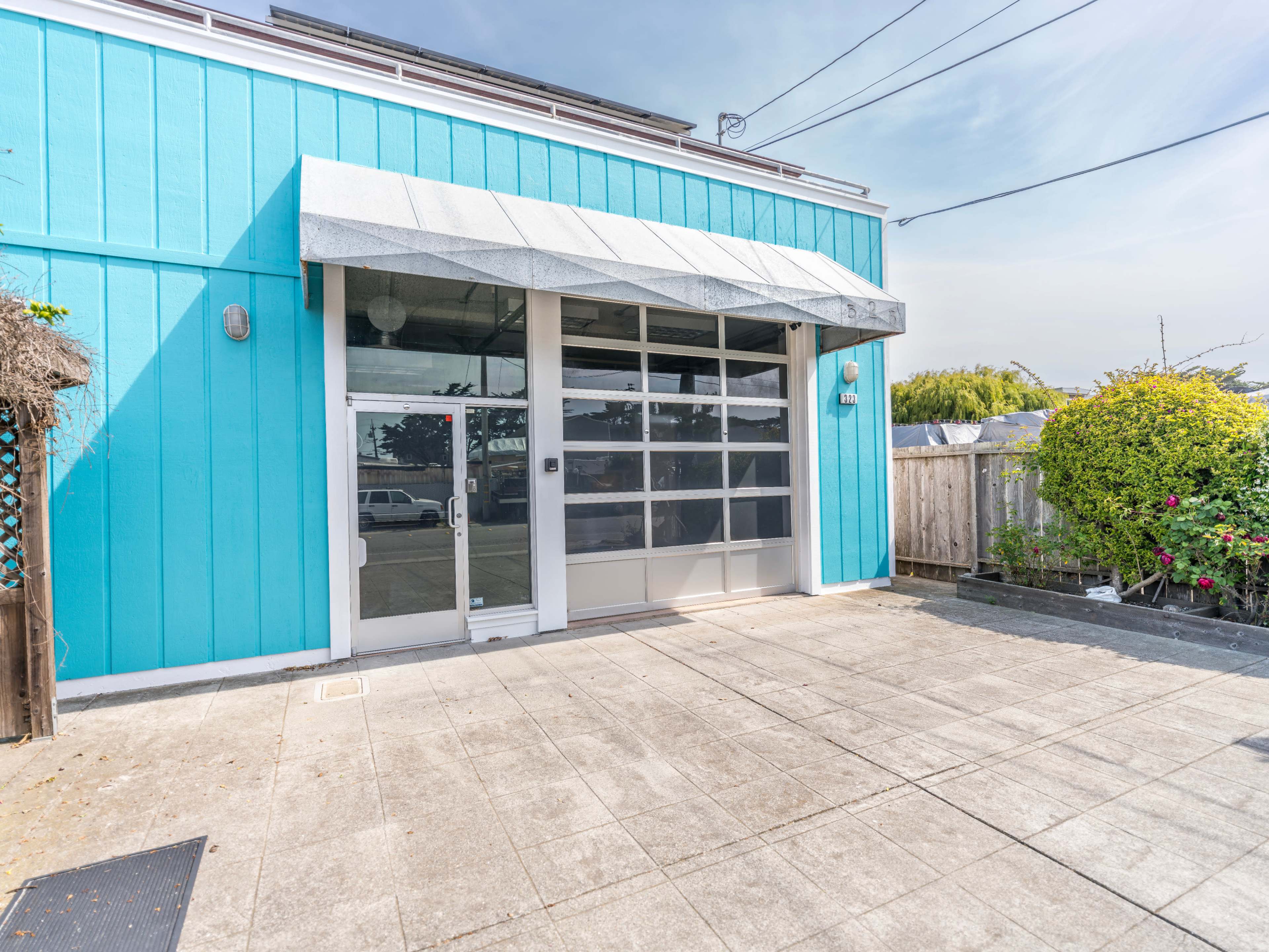 A bright blue building with a large glass door and a covered awning.