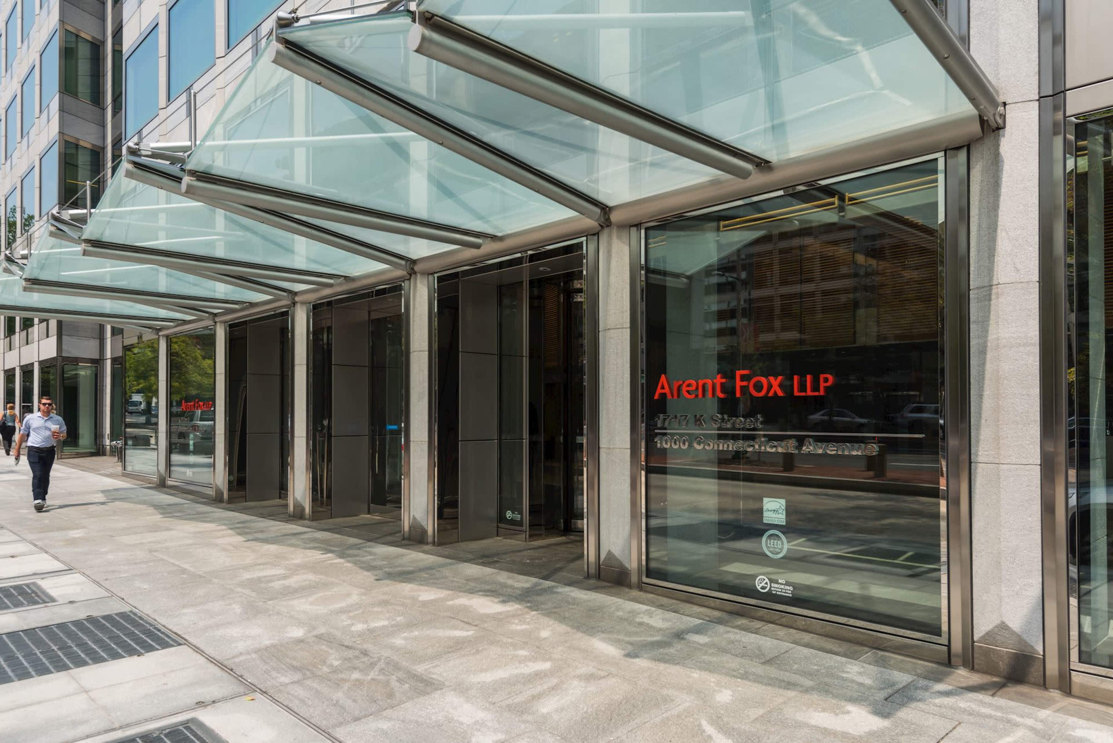 The entrance of the Arent Fox LLP office building is showcased with large glass awnings and a modern facade.