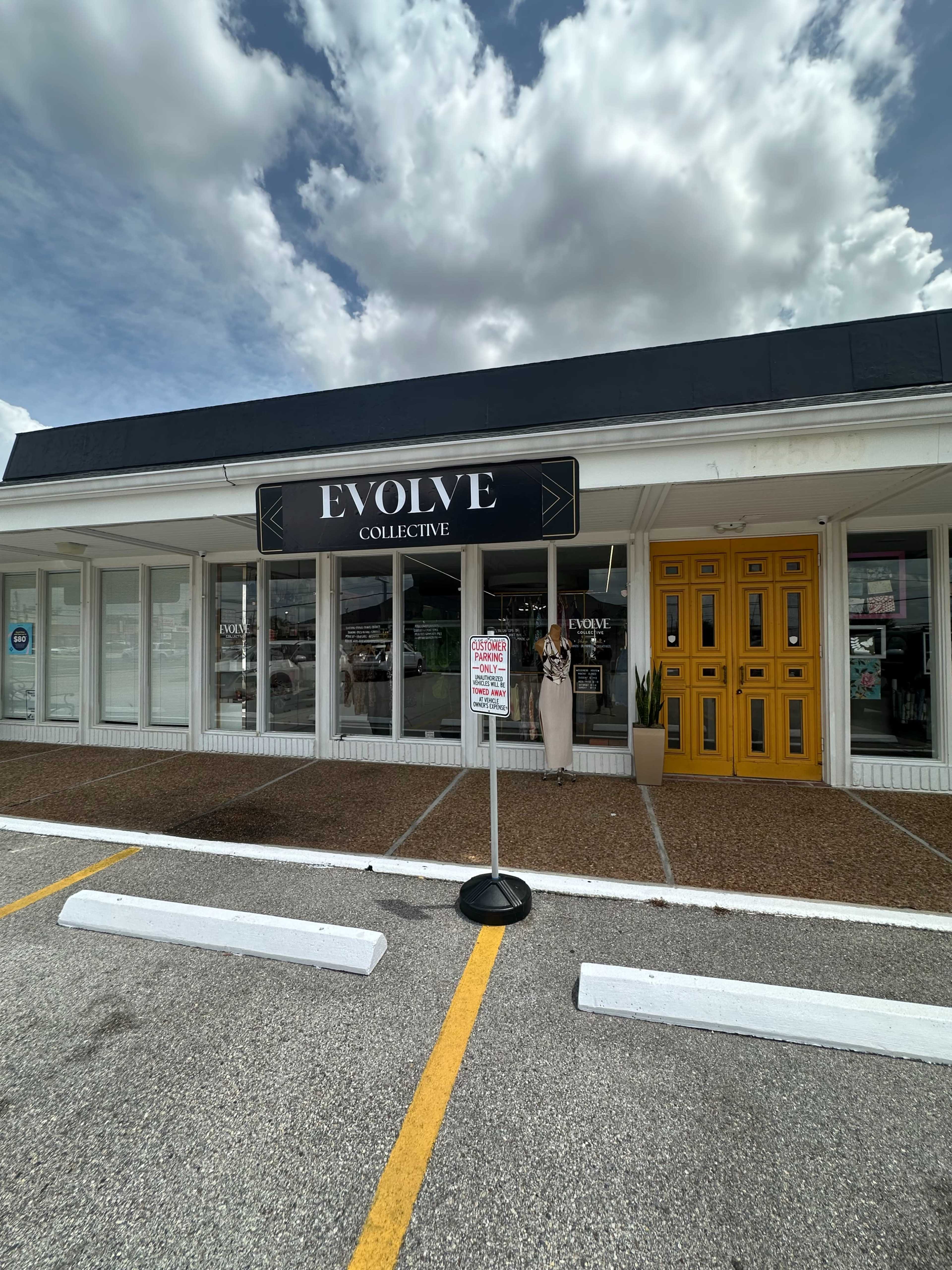The image shows a storefront named "Evolve Collective" with large windows and a bright yellow door, set against a cloudy sky.