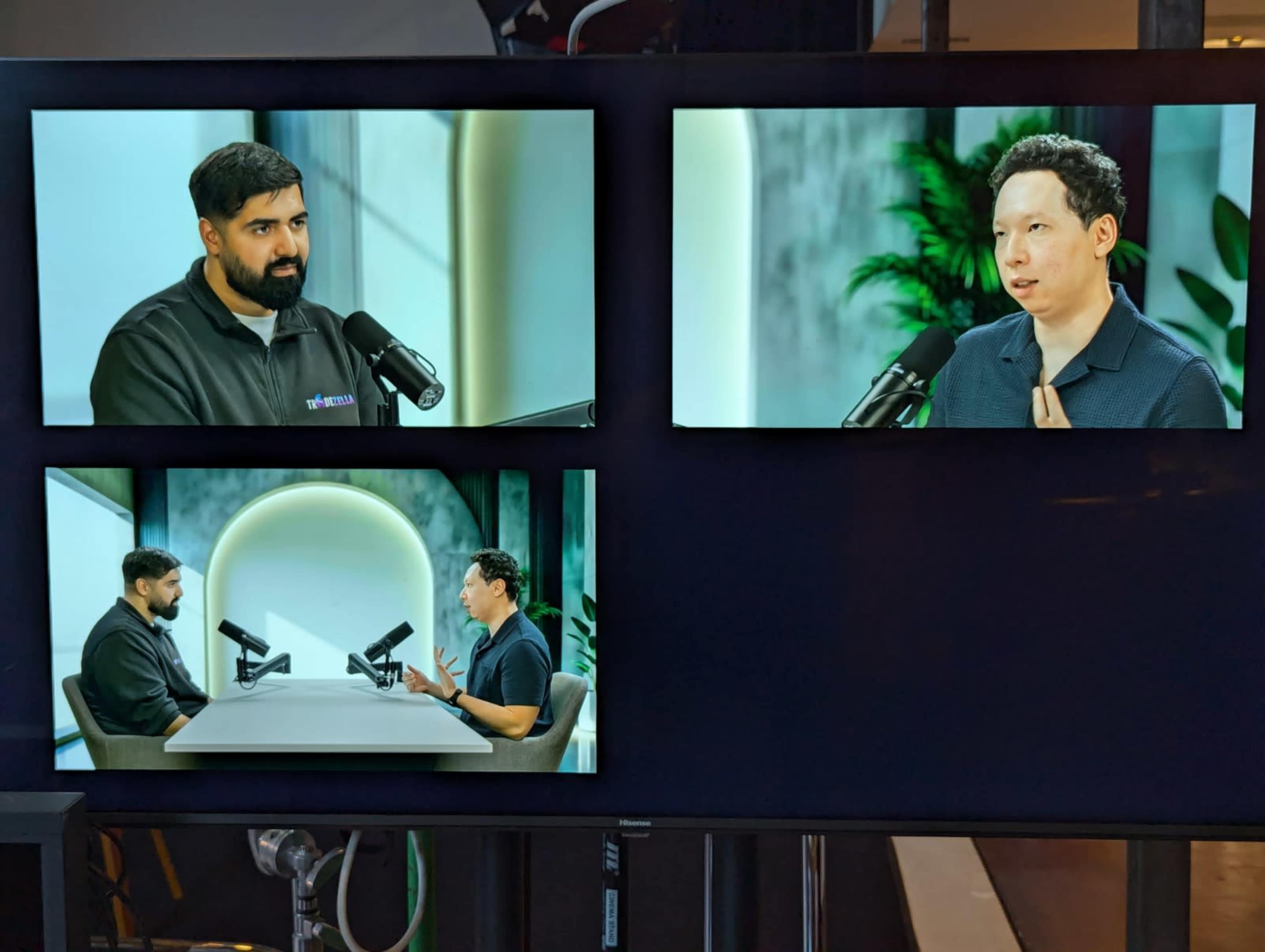 The image shows a layout of three video screens displaying two men engaged in a discussion with microphones.