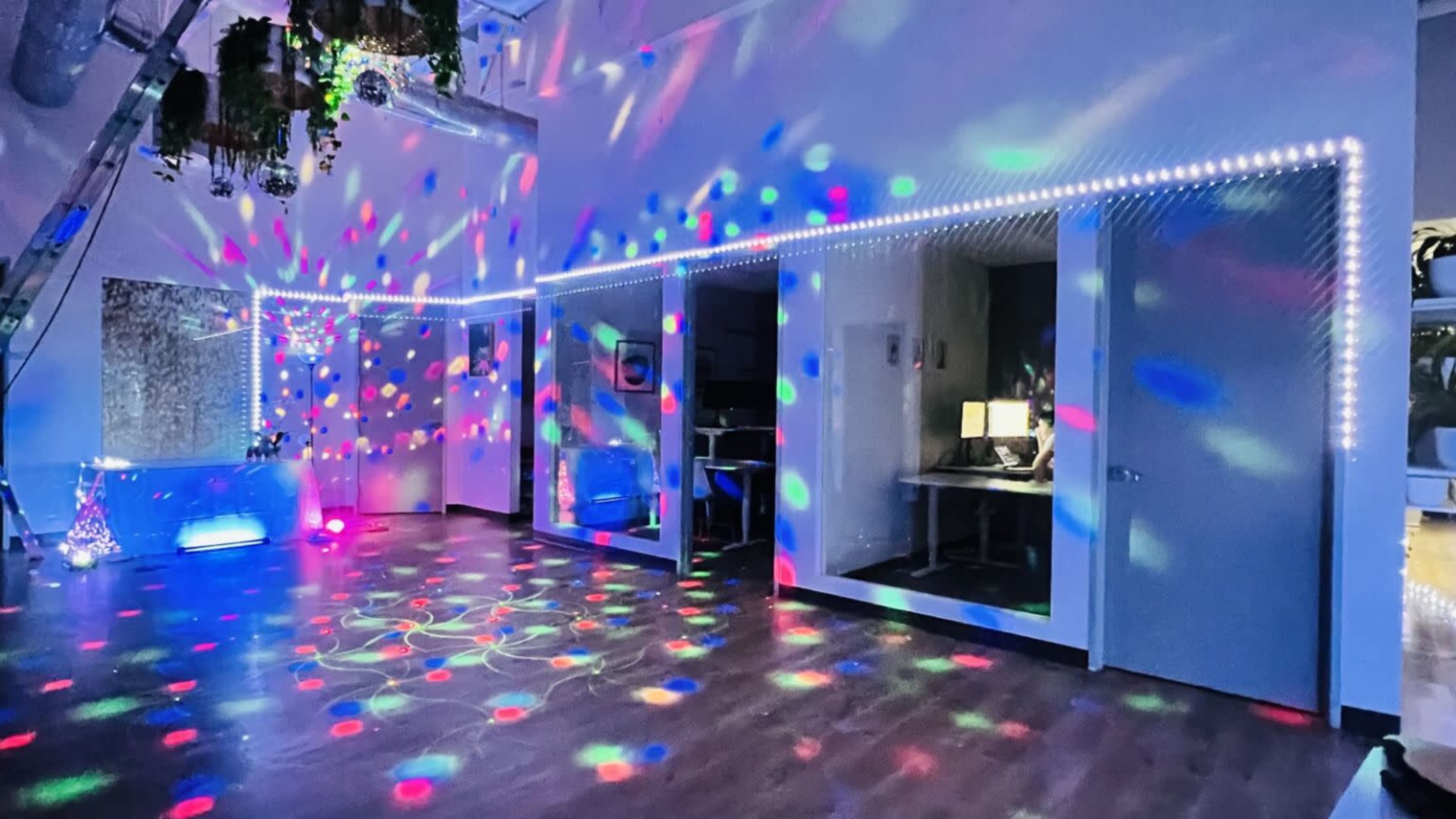 The room features colorful lights projecting patterns on the walls and floor, creating a vibrant atmosphere.