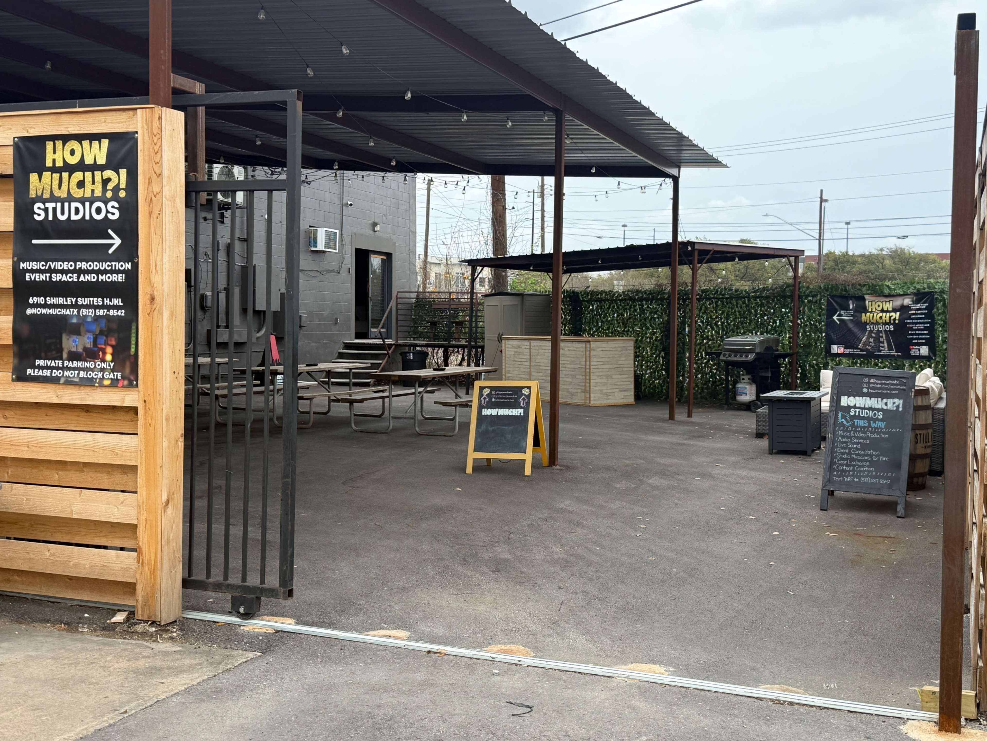 The image shows an outdoor music and video production studio area with seating, a grill, and promotional signs.