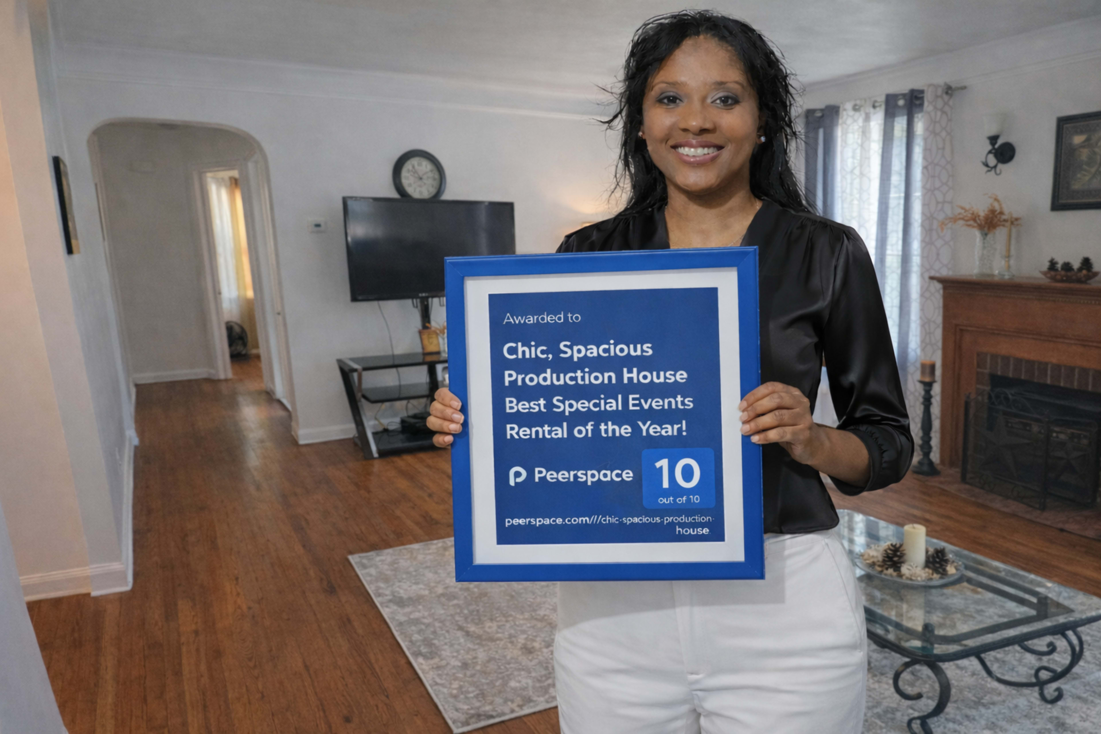 A woman holds a framed award indicating that a production house received the title of "Best Special Events Rental of the Year" with a rating of 10 out of 10.