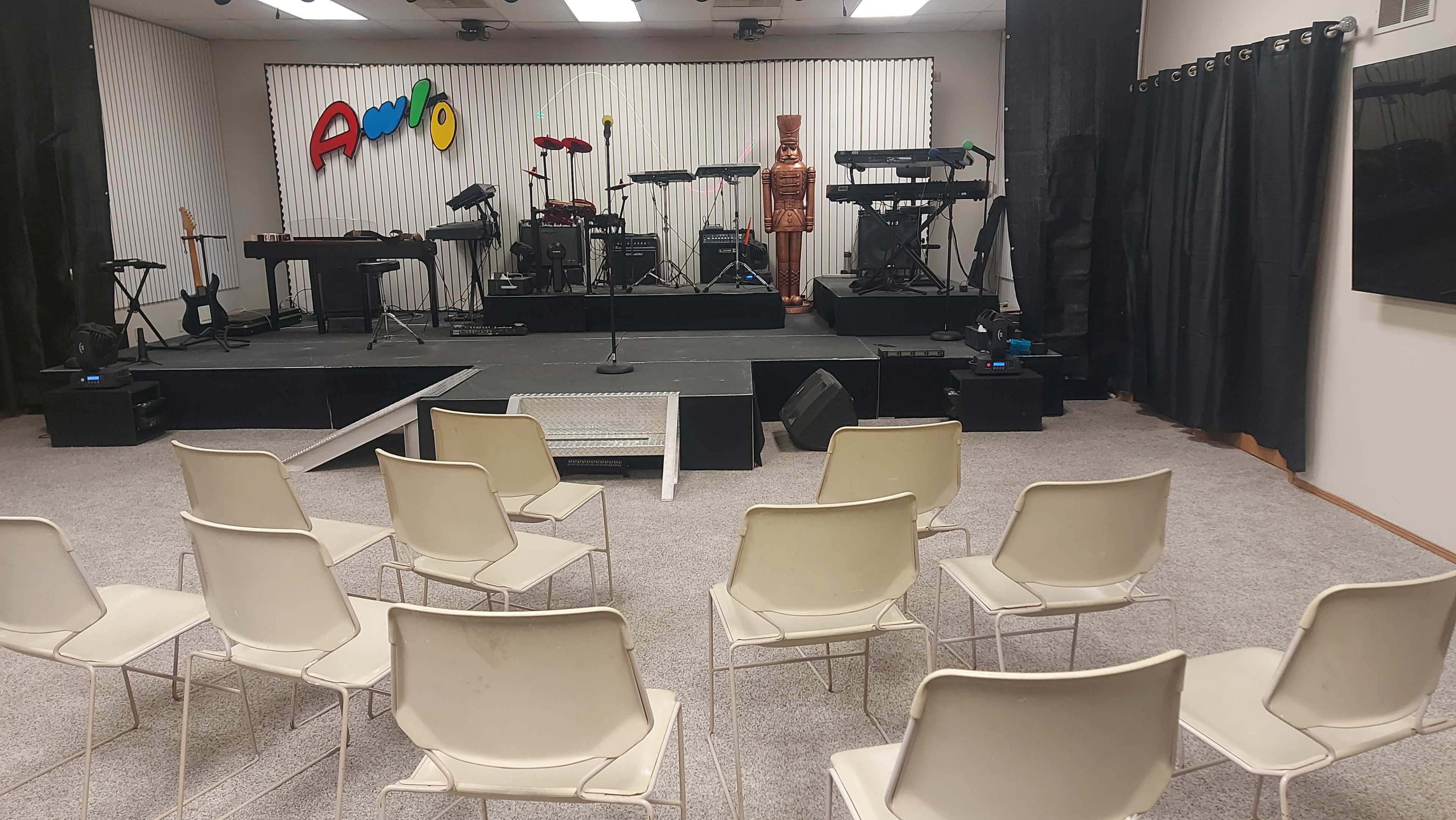A performance stage with musical instruments and chairs arranged facing it in a room labeled with the word "Apollo."