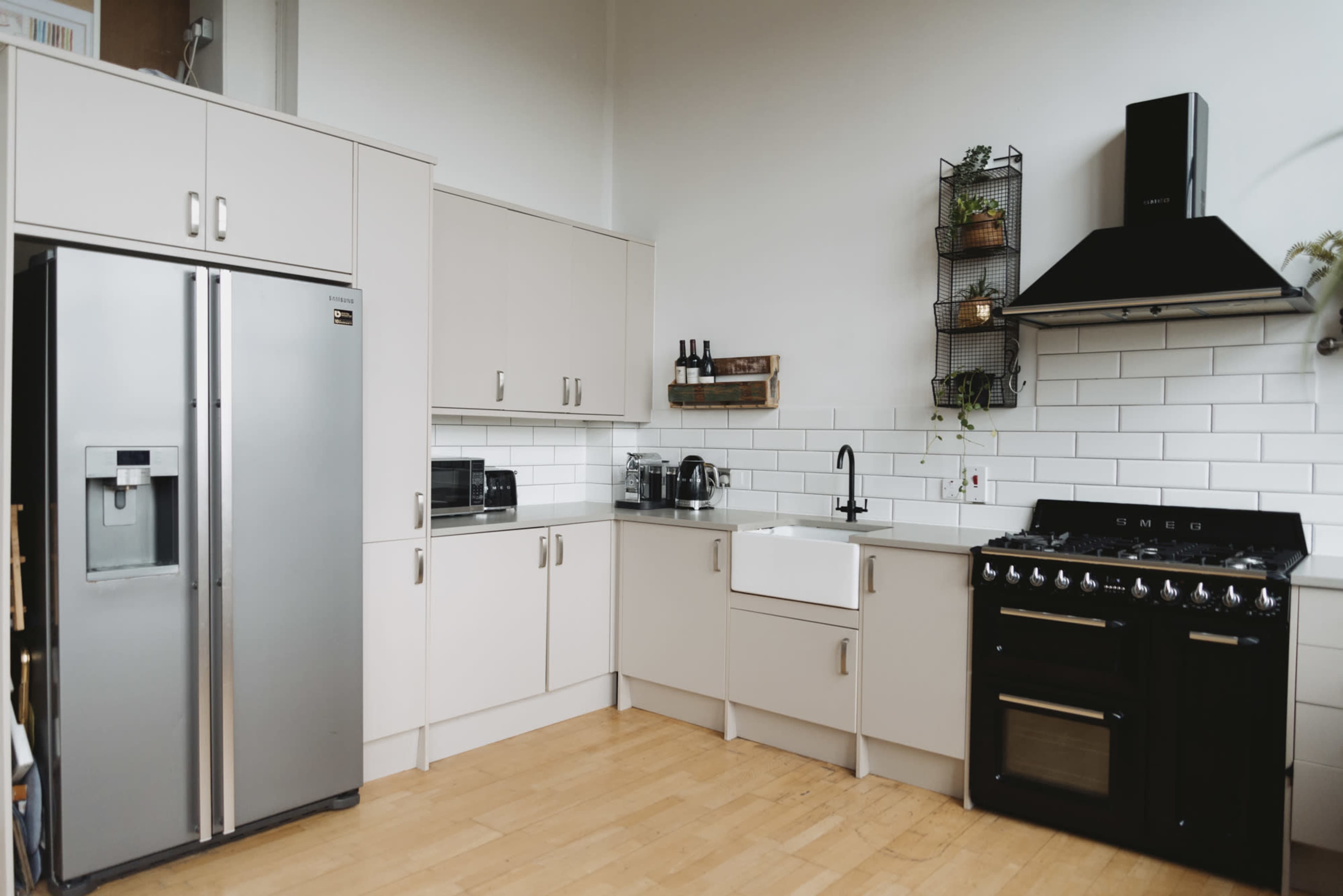 The kitchen features stainless steel appliances, light-colored cabinetry, and a gas range with a black hood.