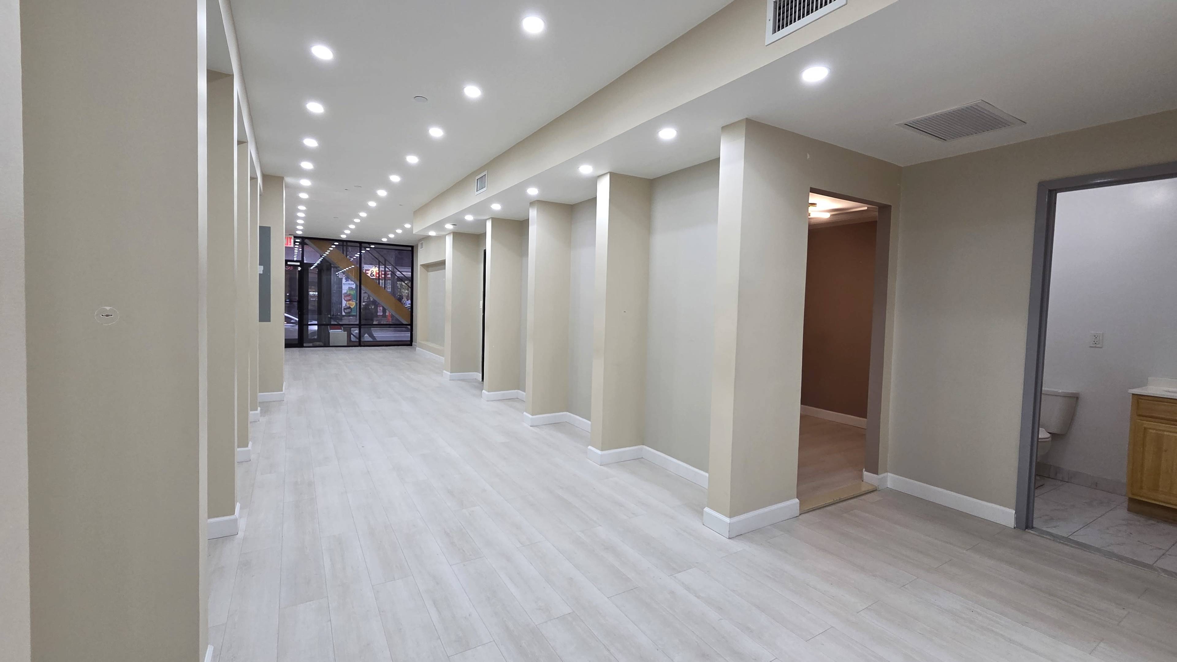 The image shows a well-lit hallway with multiple columns and a door leading to another room at the end.