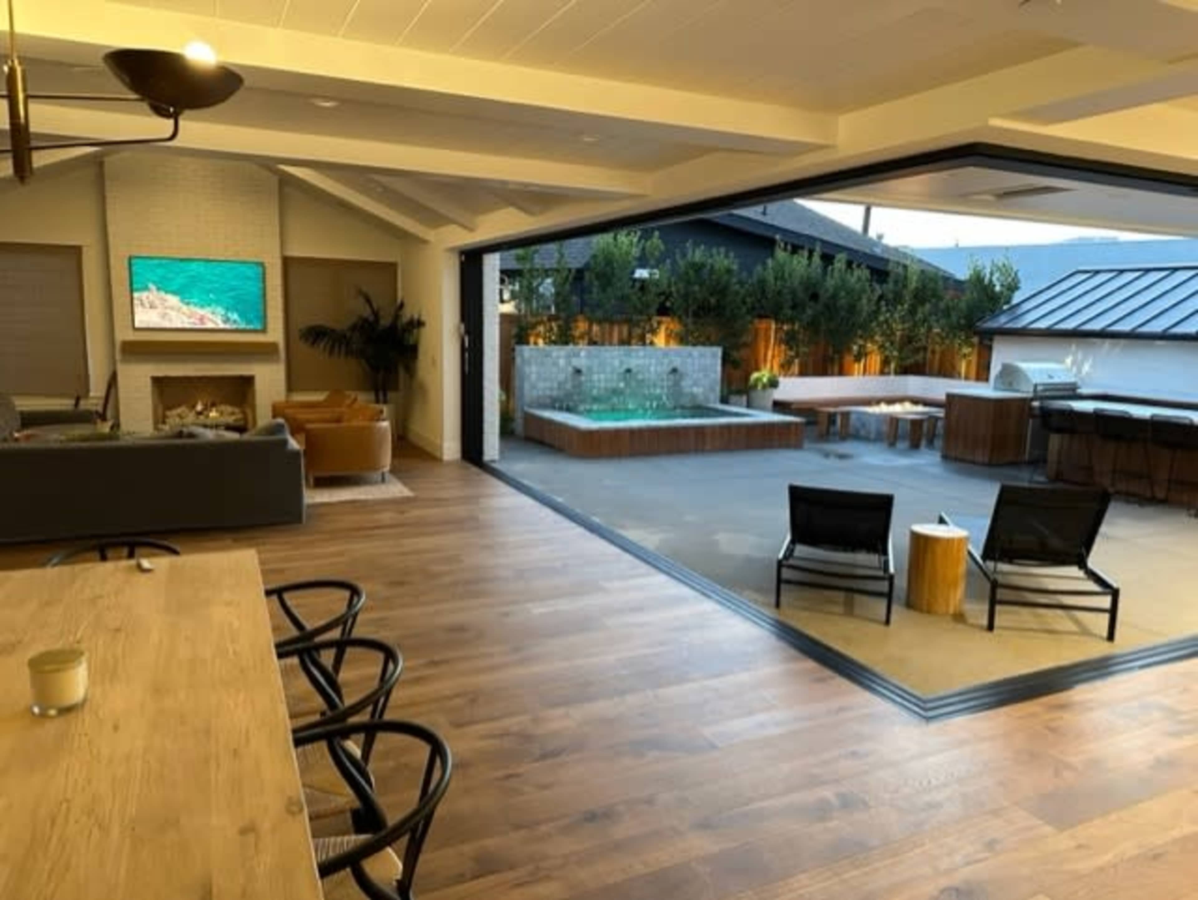 A spacious open-concept living area with a view of an outdoor pool and patio through large sliding glass doors.