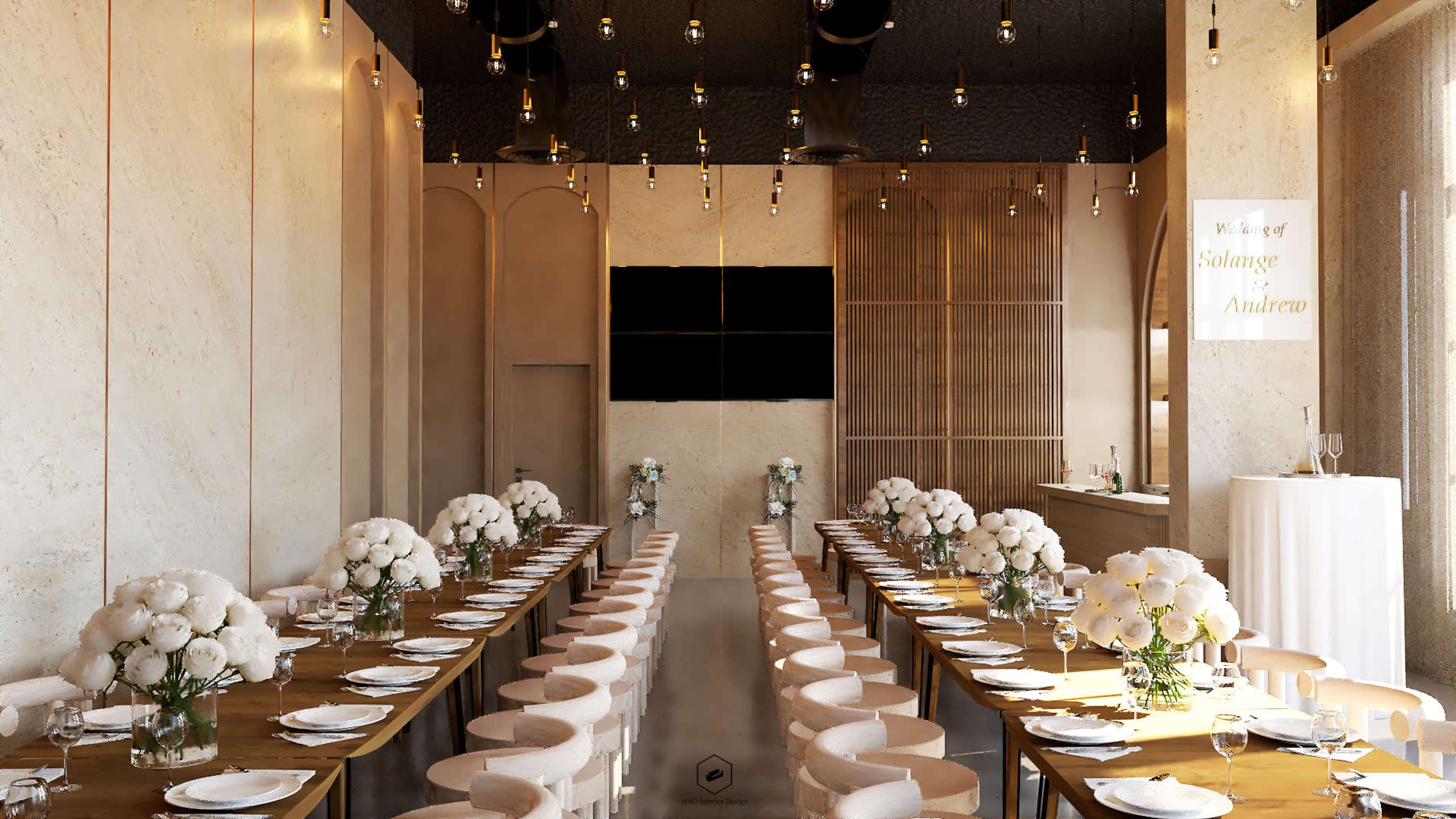 A modern dining space features long wooden tables adorned with white floral centerpieces, surrounded by beige chairs and illuminated by pendant lights.