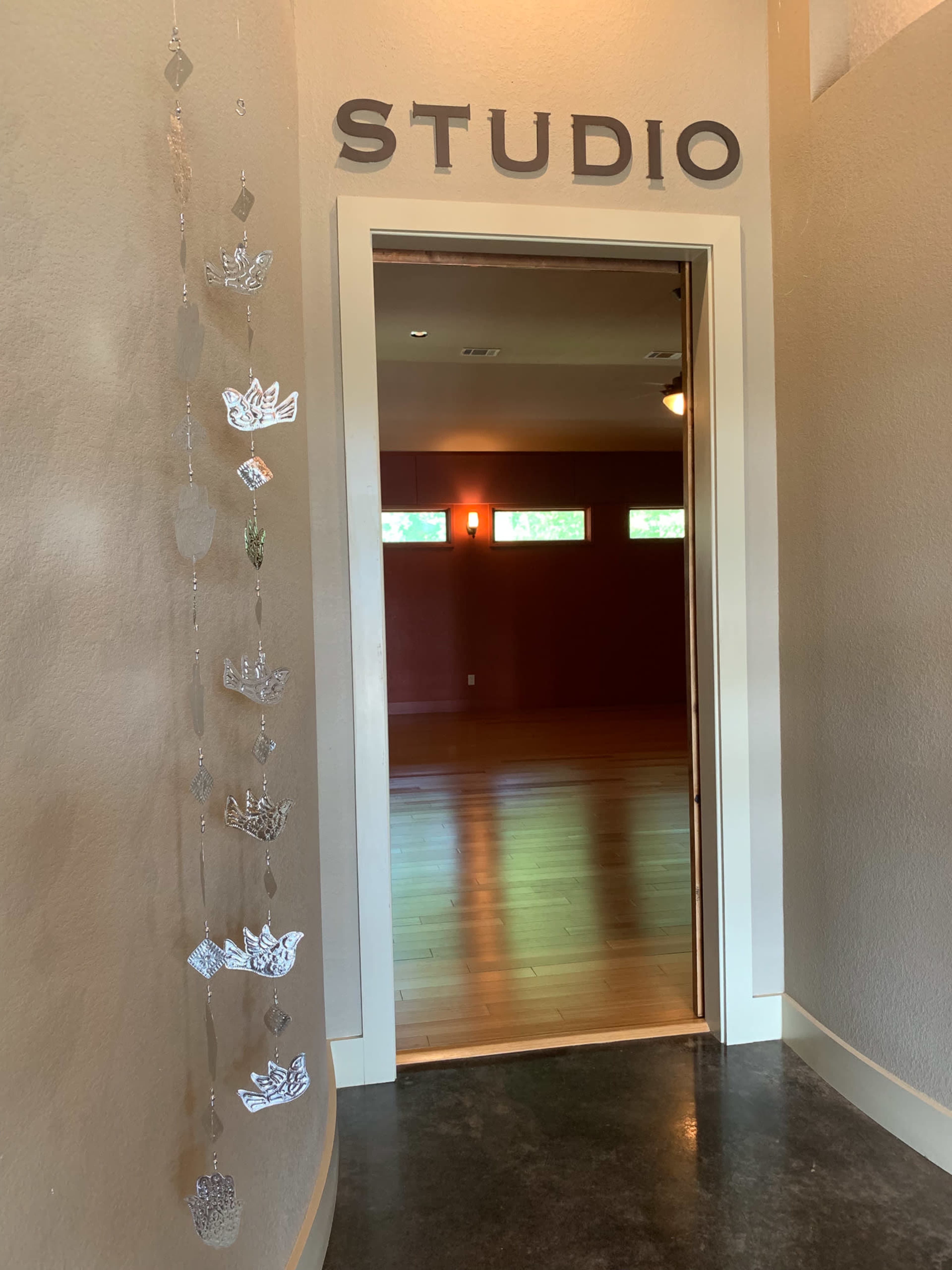 A doorway labeled "STUDIO" leading into a room with wooden floors and red walls.