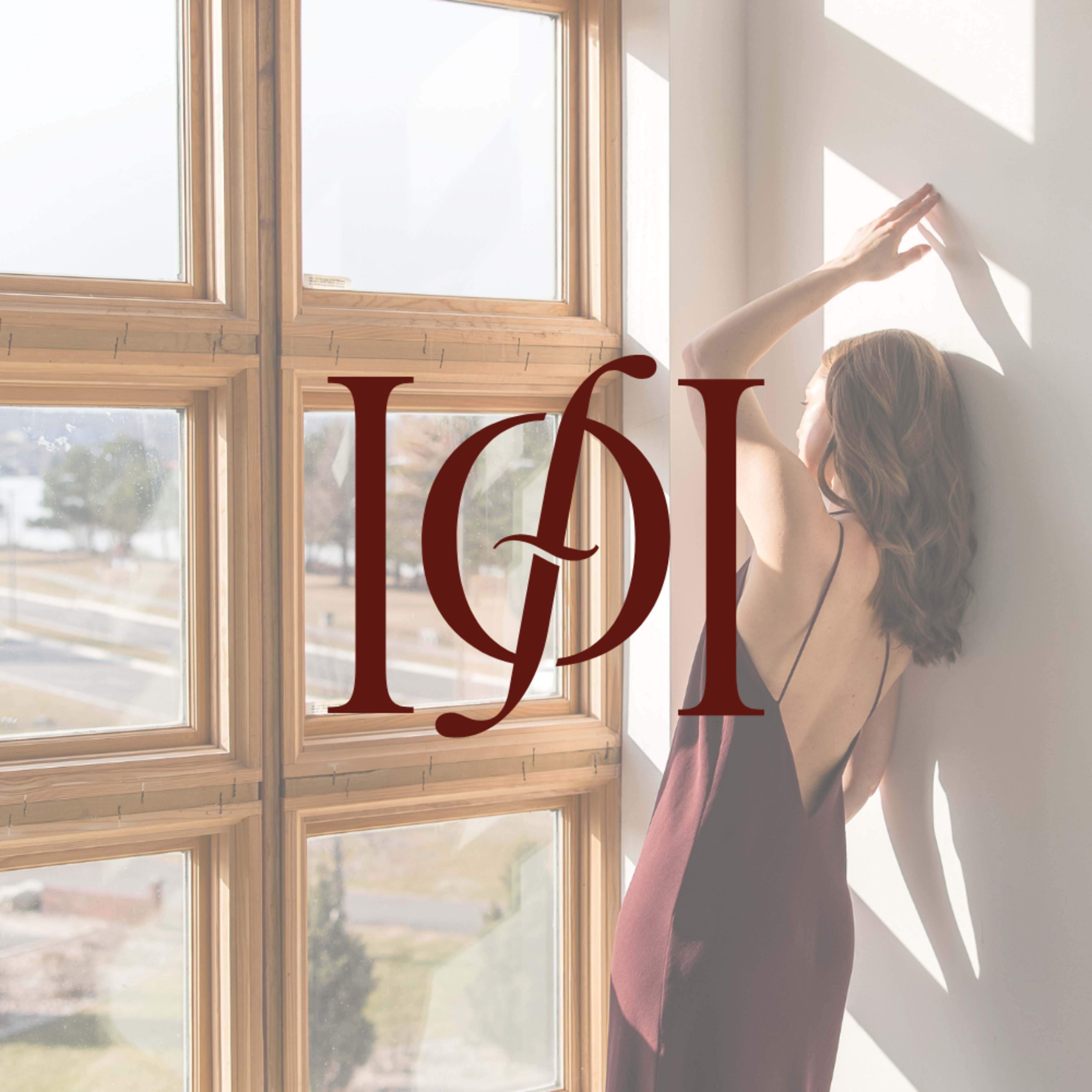 A person stands against a large window, framed by natural light, while an elegant logo is superimposed in the foreground.