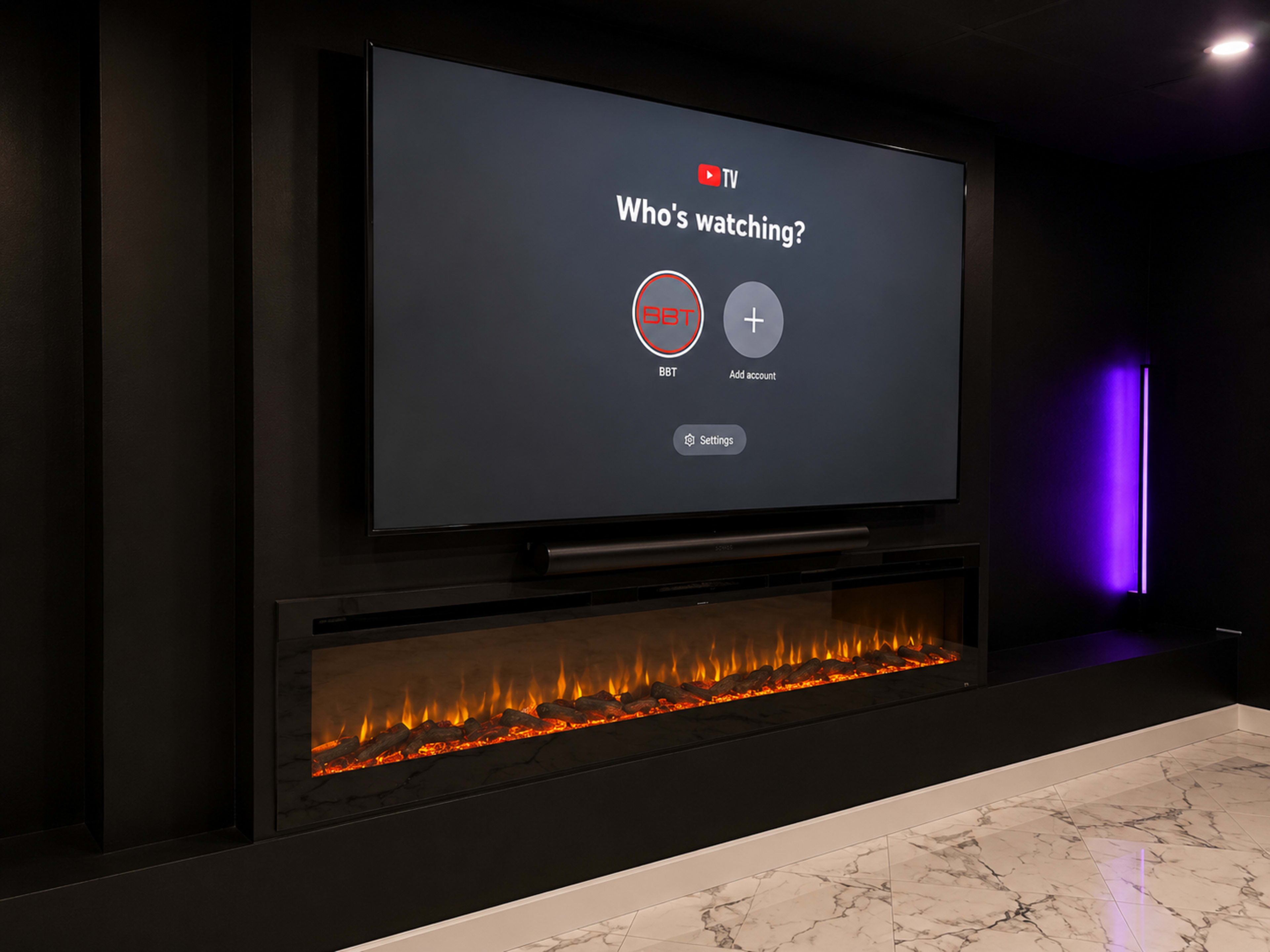 A large flat-screen TV is mounted on a black wall above a modern electric fireplace with glowing orange lights, displaying a “Who's watching?” screen.