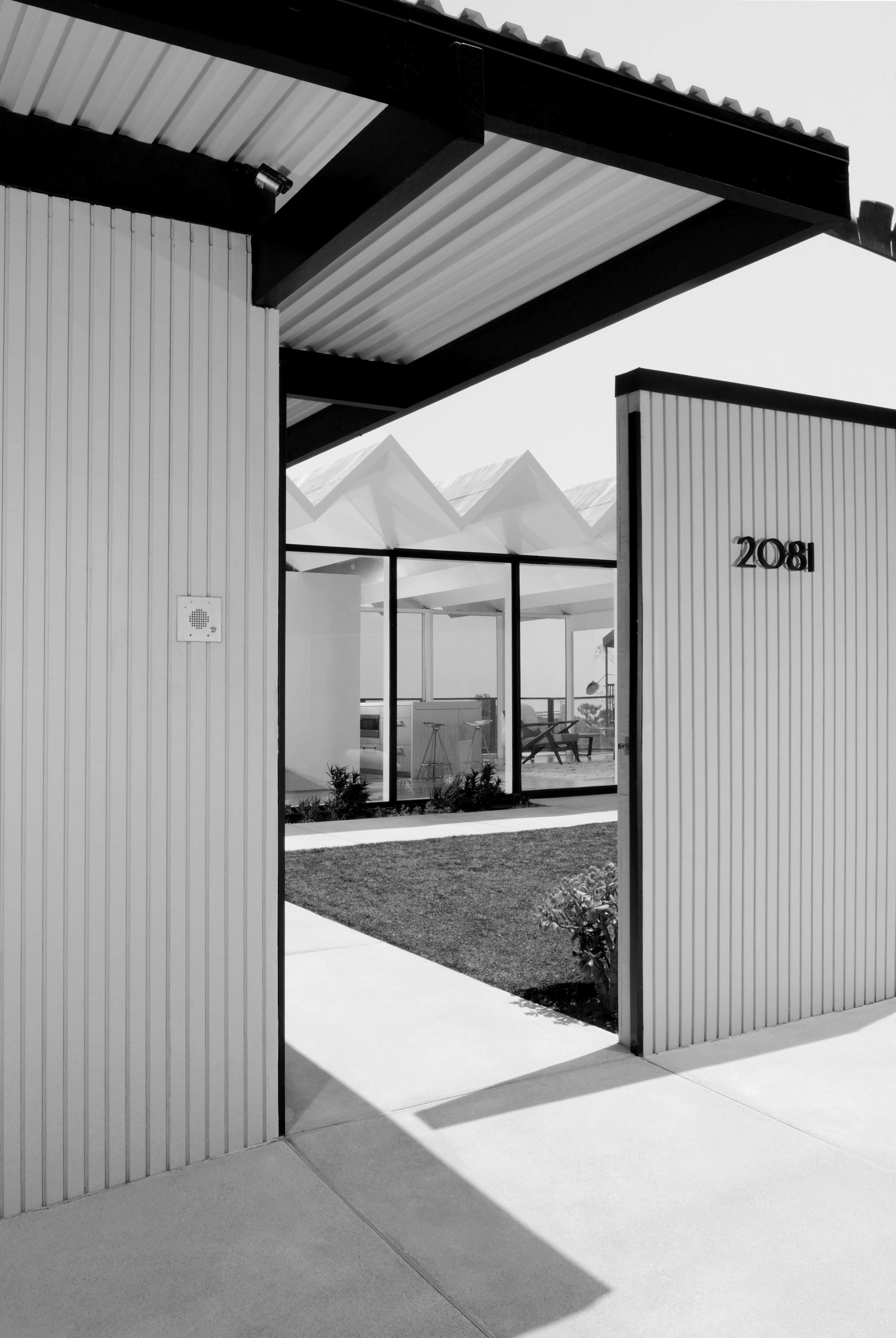 The entrance features a modern, minimalist design leading to a courtyard with a low wall, labeled "2081."