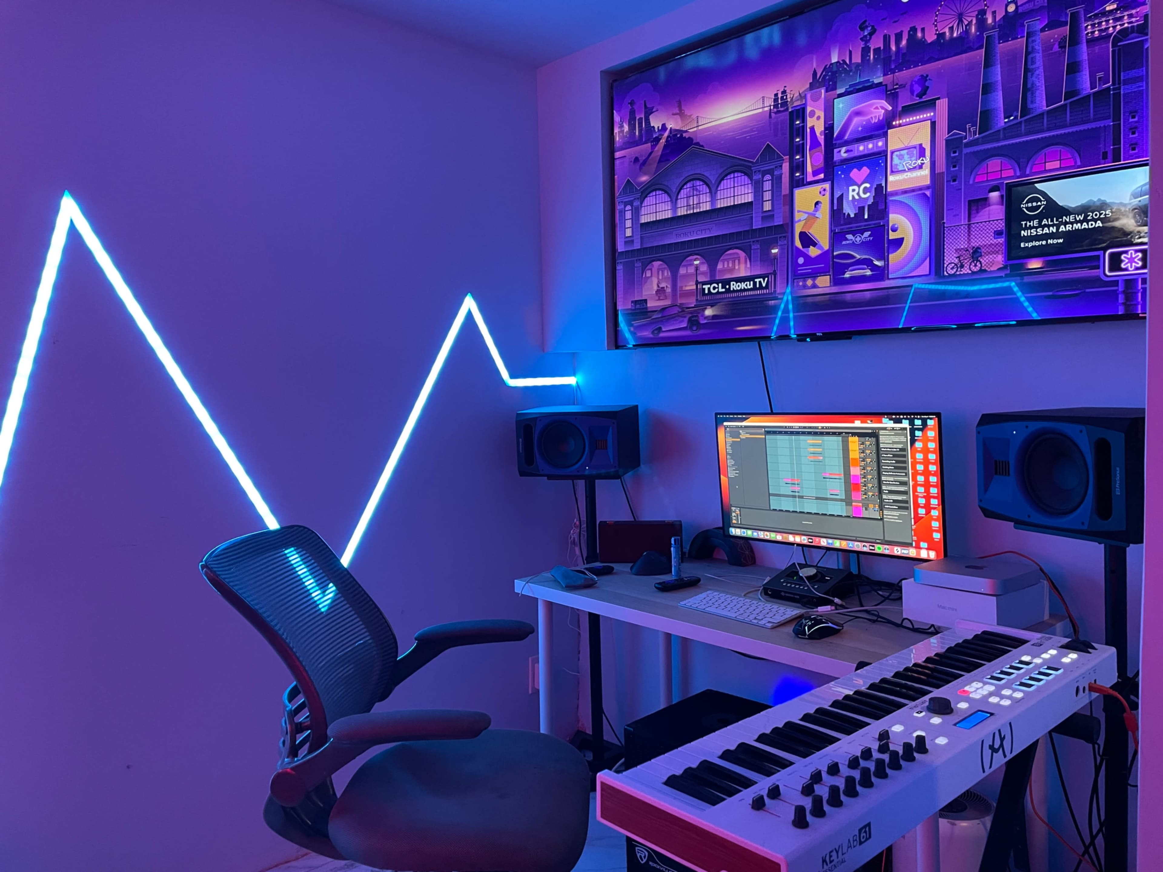 The image depicts a modern music production studio featuring a computer setup with speakers, a MIDI keyboard, an ergonomic chair, and LED strip lighting on the wall.