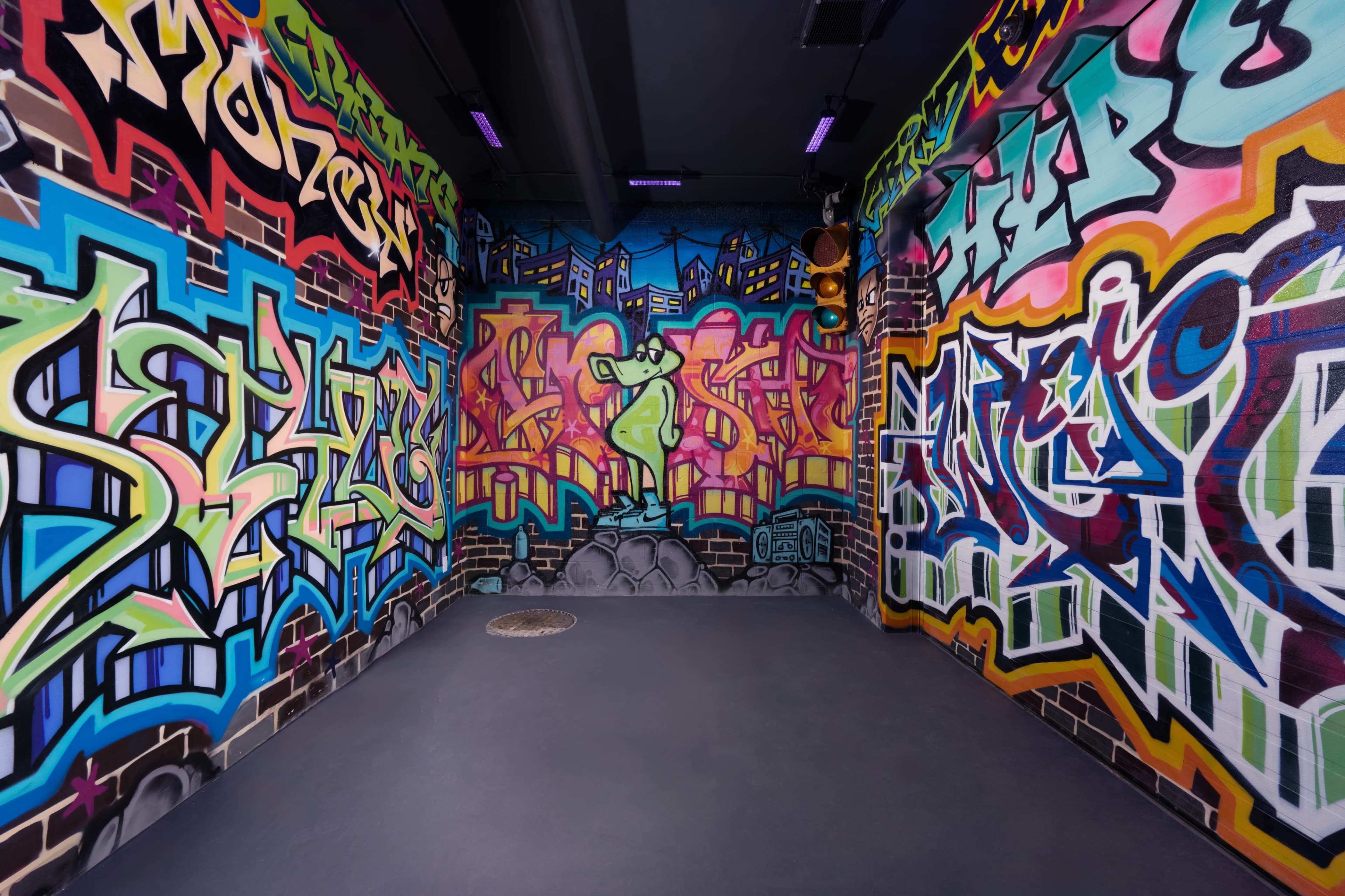 A corner of a room decorated with colorful graffiti on its walls.