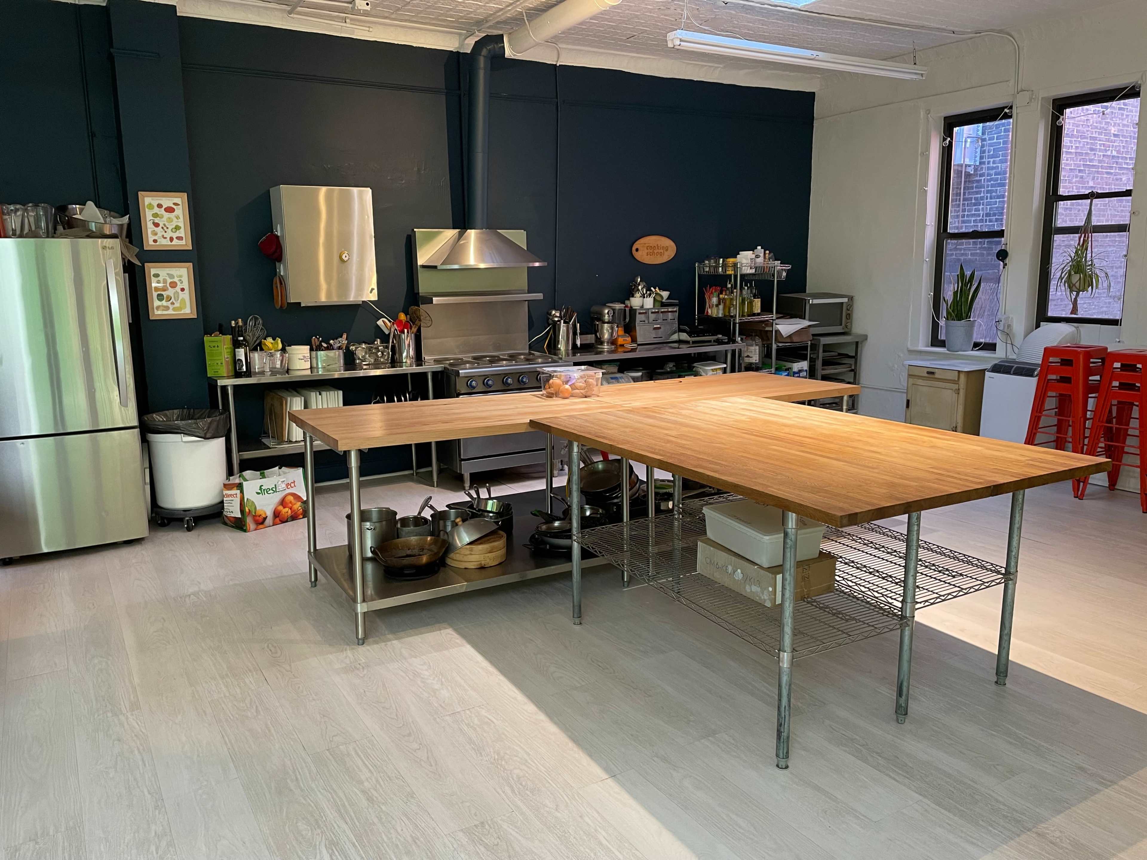 A spacious kitchen with stainless steel appliances, a large wooden island, and various cooking utensils arranged on countertops.