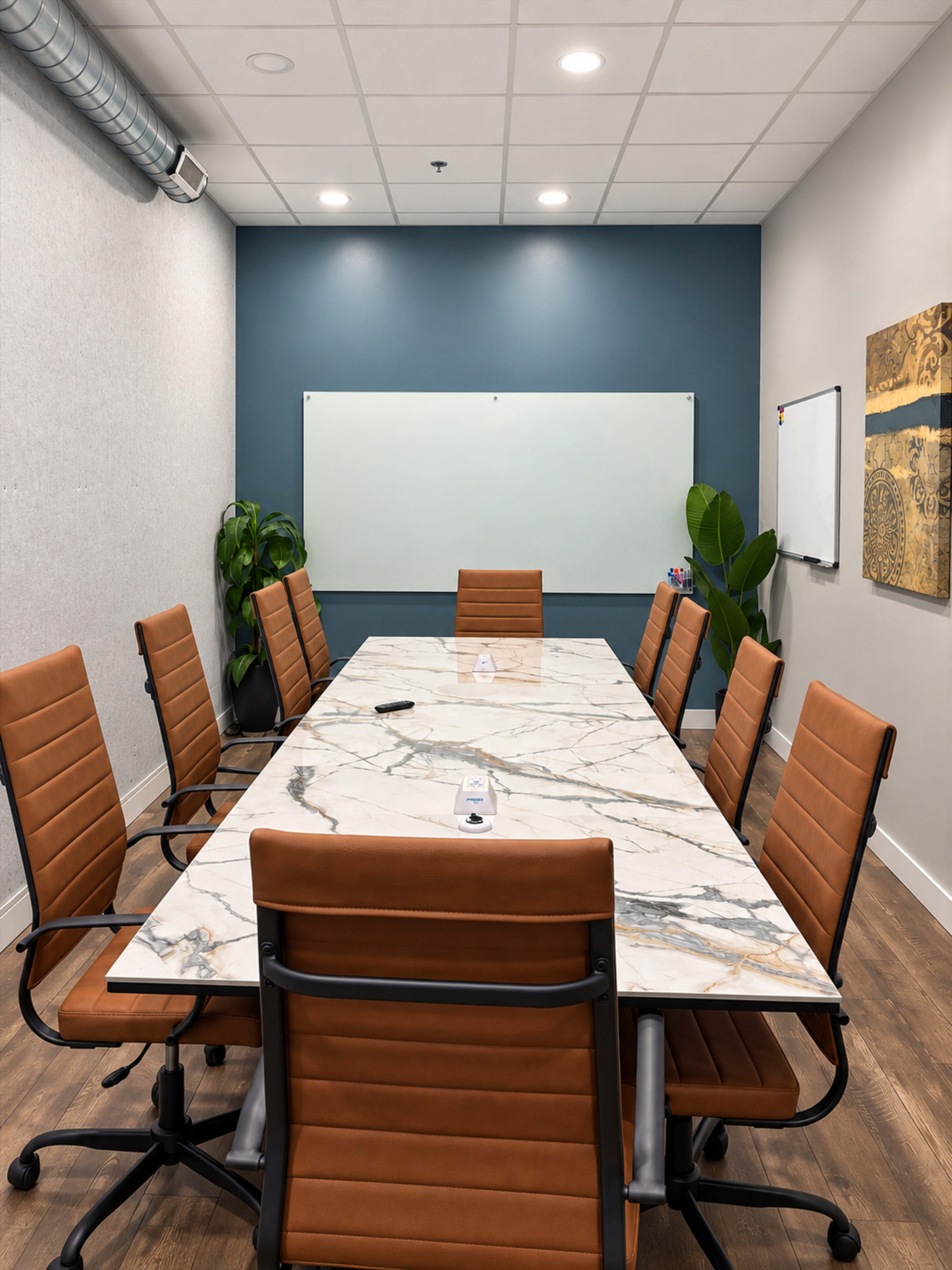 A modern conference room features a long marble table surrounded by orange leather chairs, with a whiteboard and wall art in the background.