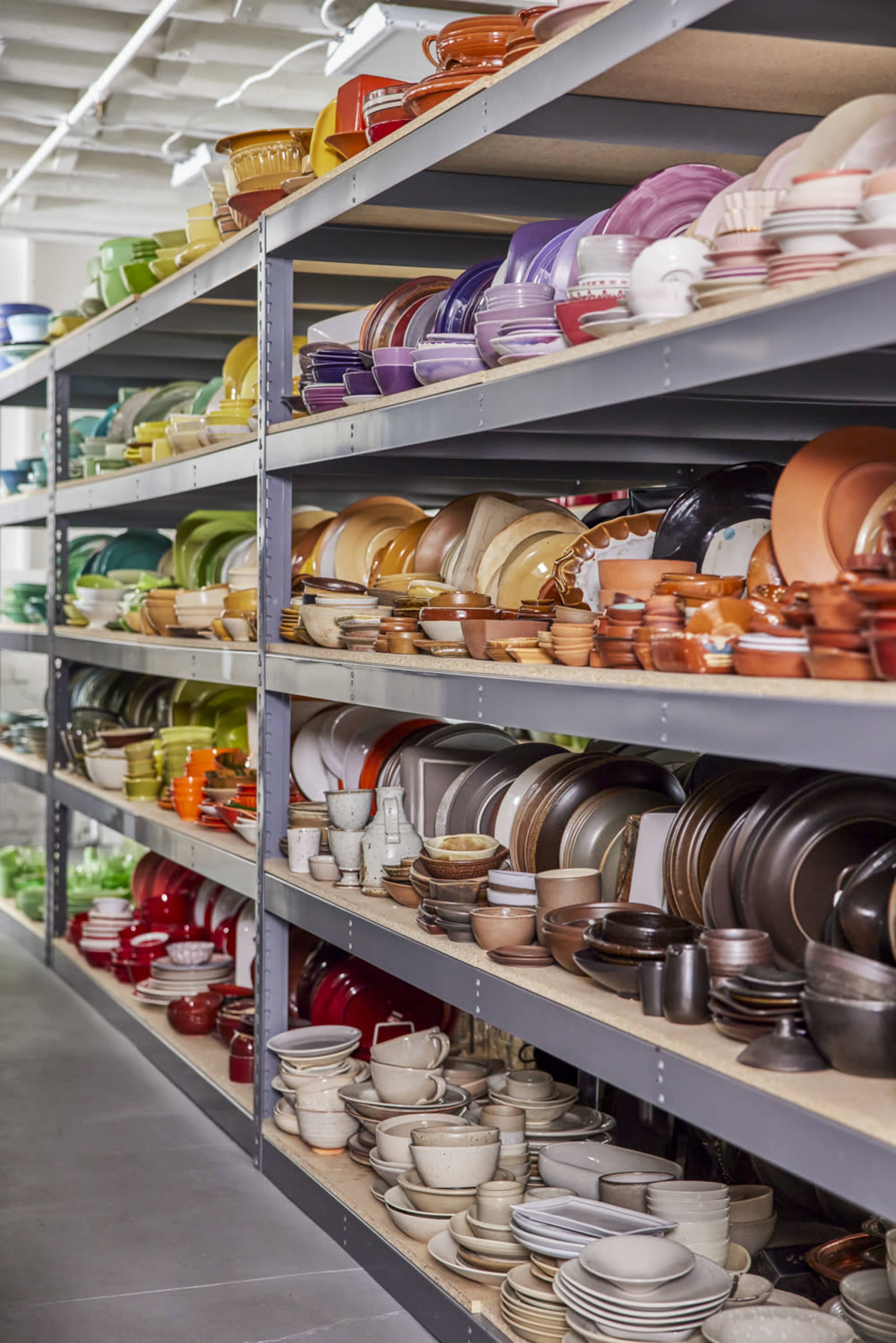 A storage area displays neatly arranged shelves filled with various types of colored dishes and cookware.