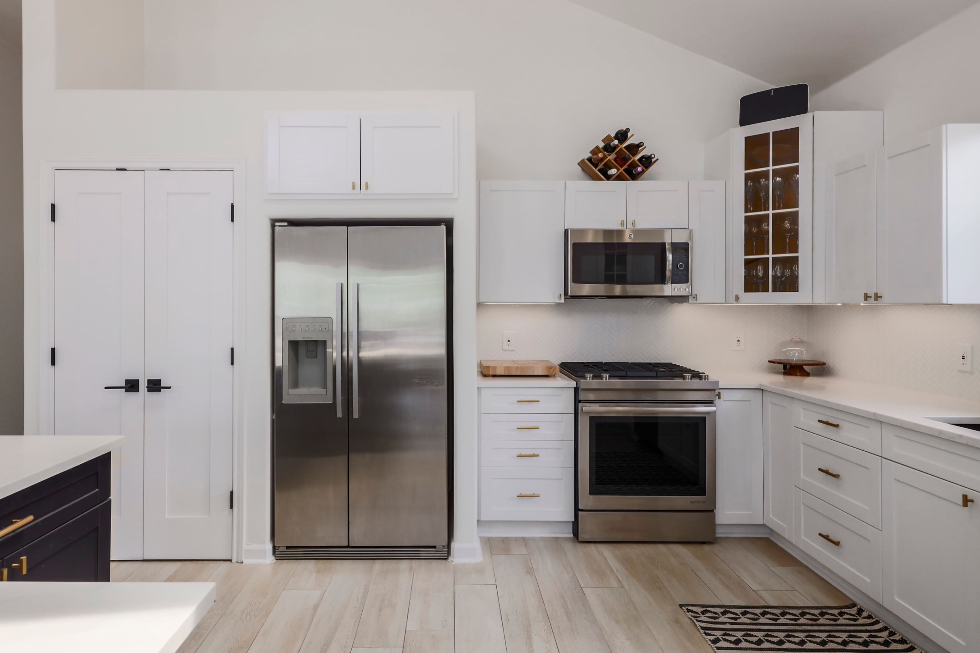 The kitchen features stainless steel appliances, white cabinetry, and a wooden countertop.
